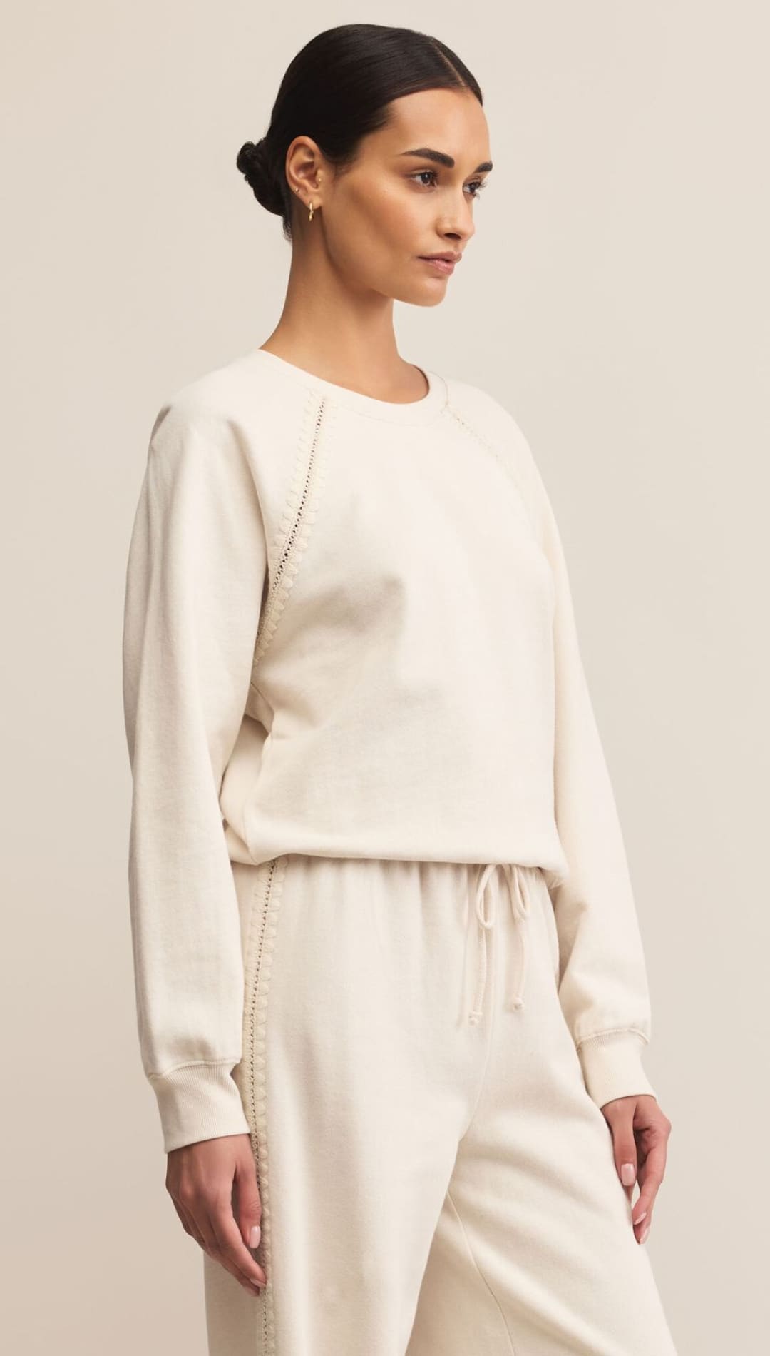 Cream cashmere sweater with drawstring waist and long sleeves.