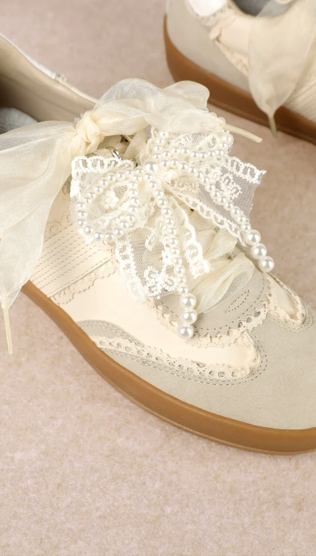 White lace and pearl embellished sneaker with gum sole.