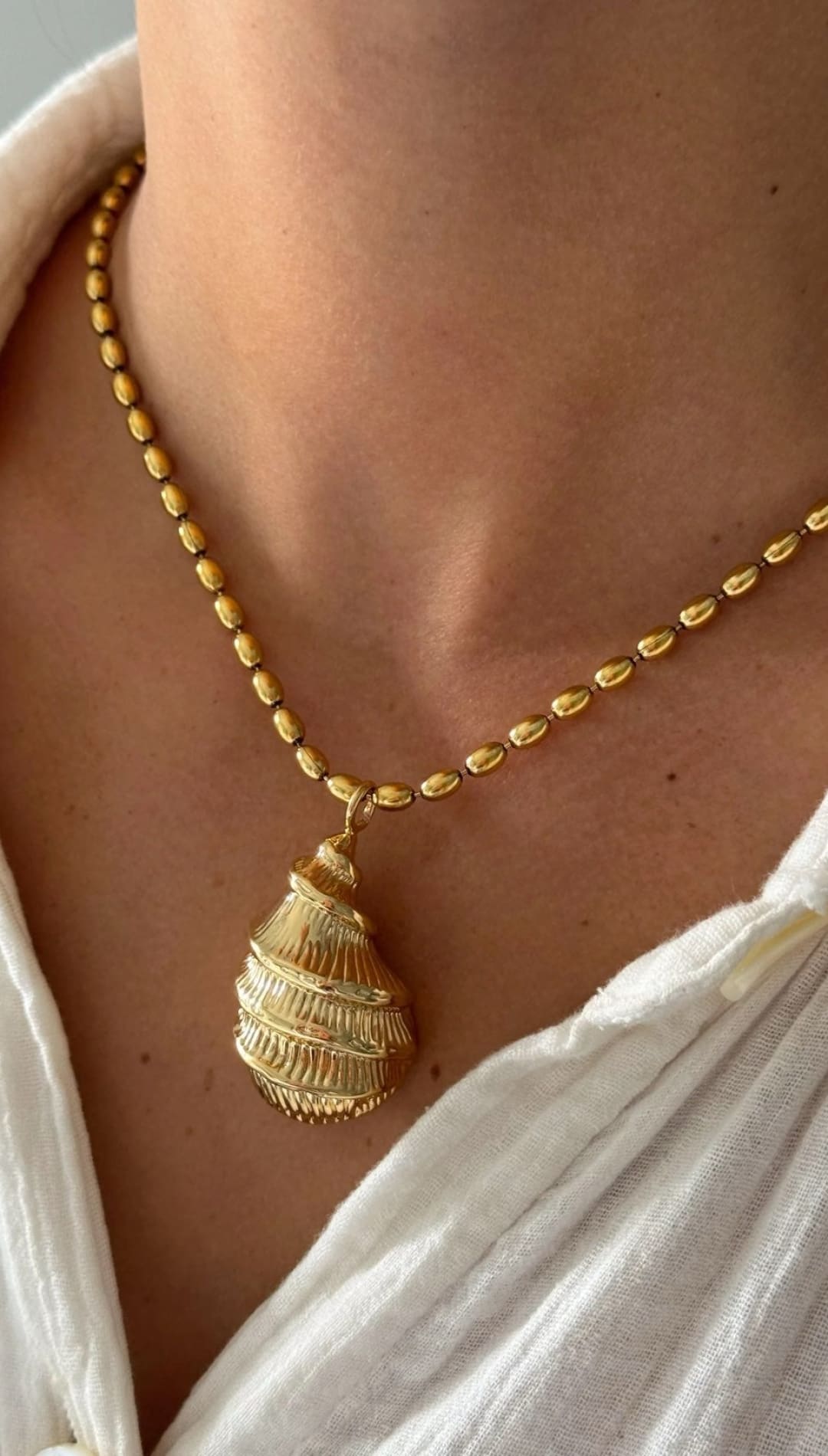Gold shell pendant necklace.