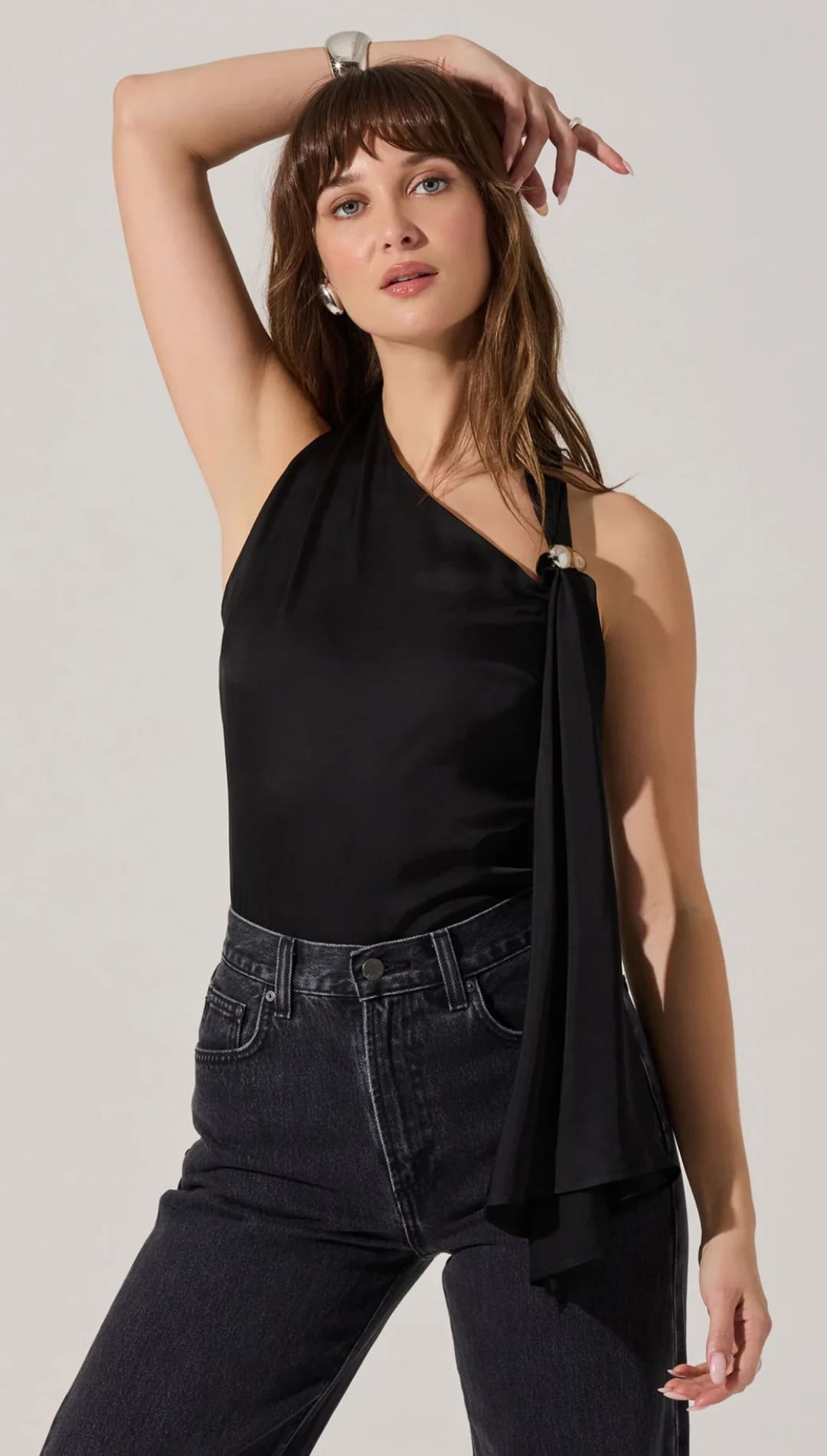 Women’s black one-shoulder top with a draped detail and a decorative ring.