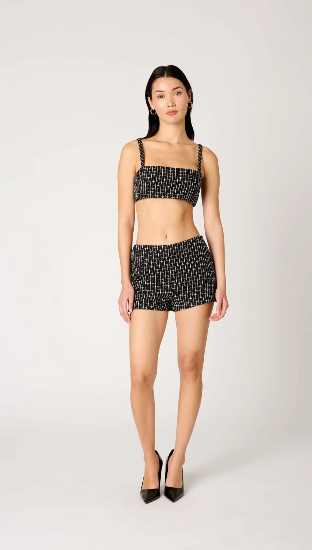 Black and white checkered shorts with thin straps, likely made of cotton or polyester blend.