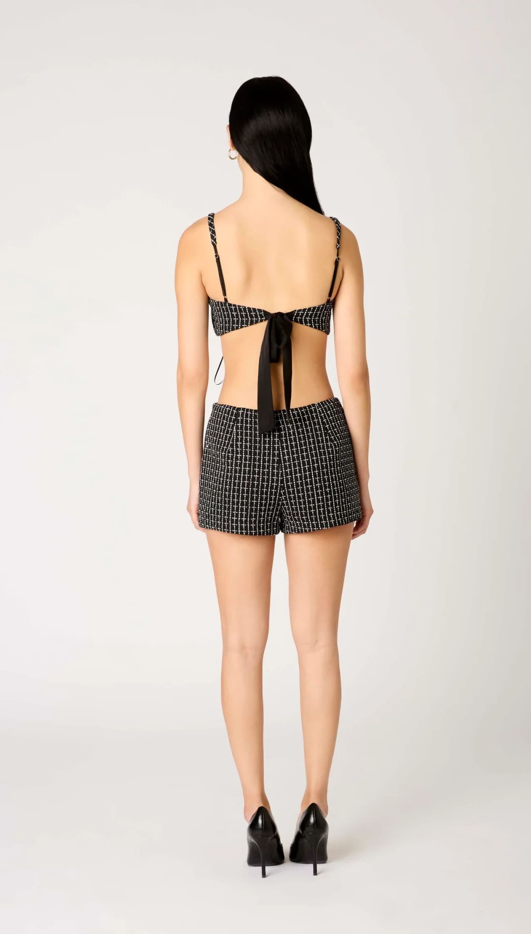 Black and white houndstooth print shorts with a bow at the waist.