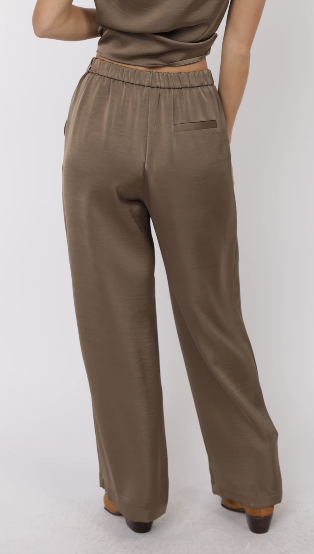 Women’s relaxed-fit, wide-leg, high-waisted, brown satin trousers with an elastic waistband and a back welt pocket.
