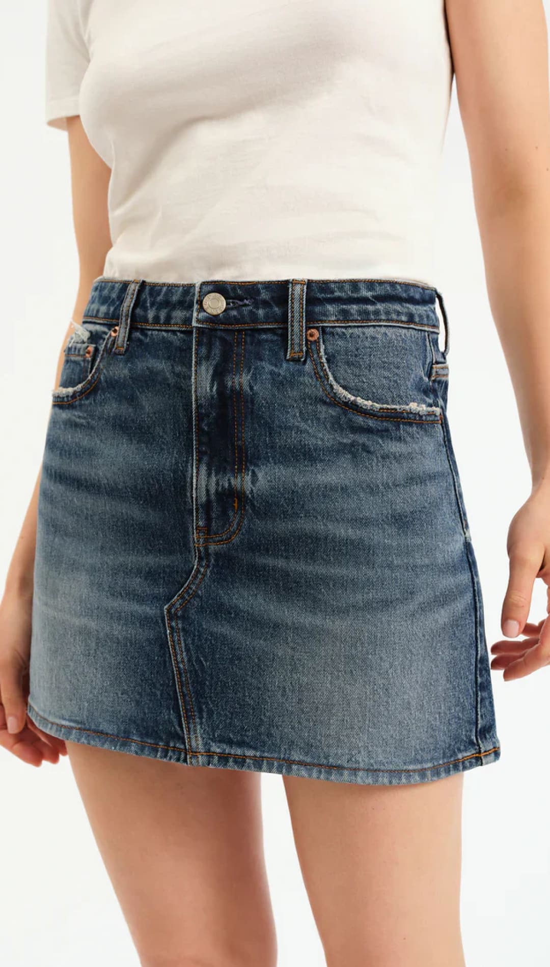 A-line denim mini skirt with a faded wash and frayed pockets.