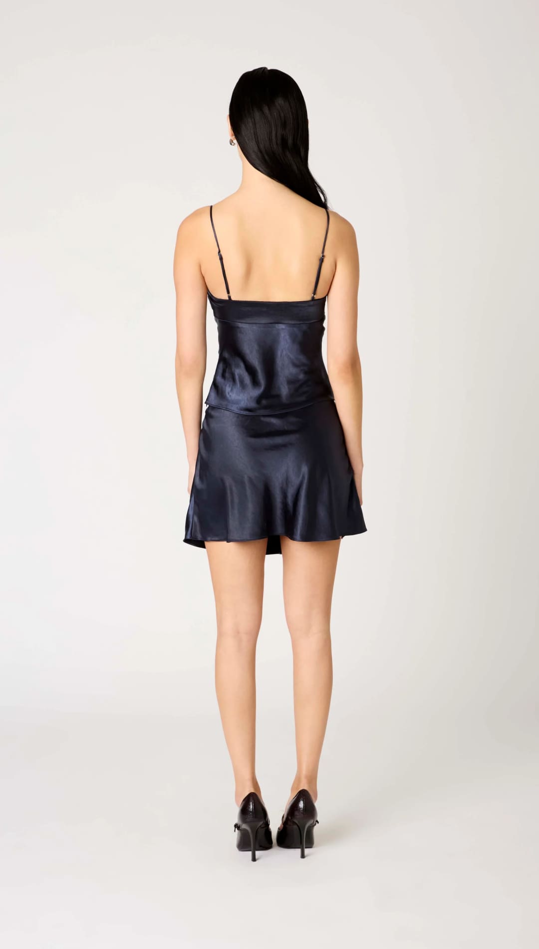 Women’s navy blue satin slip dress with spaghetti straps and a flared hem.