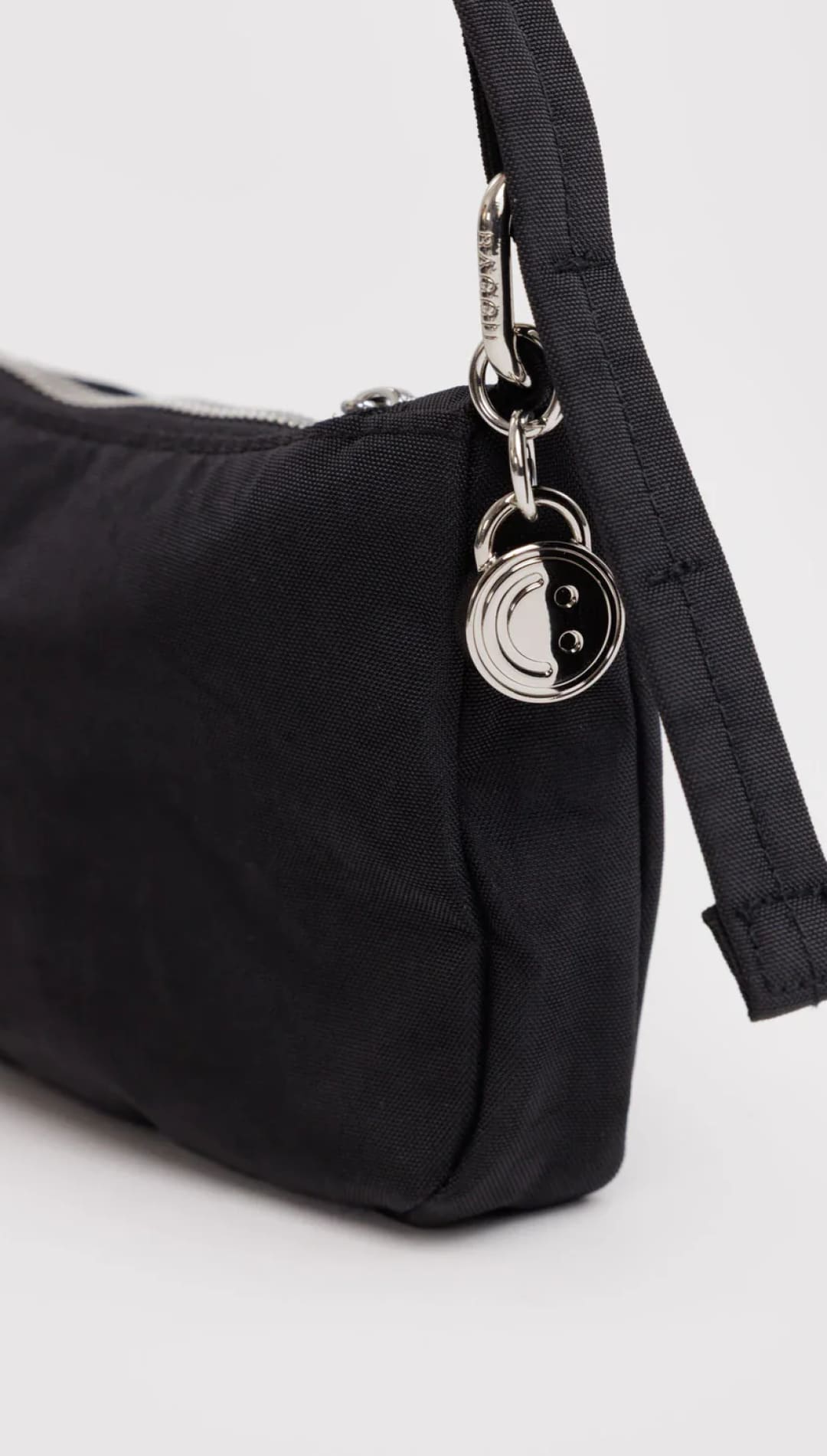 Black nylon shoulder bag with silver hardware and yin-yang charm.