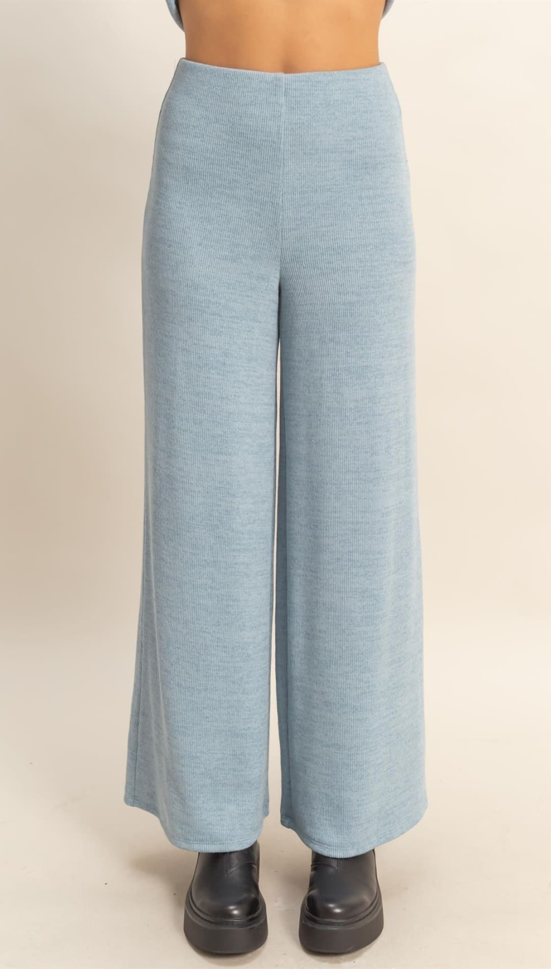 Light blue wide-leg pants paired with chunky black boots.
