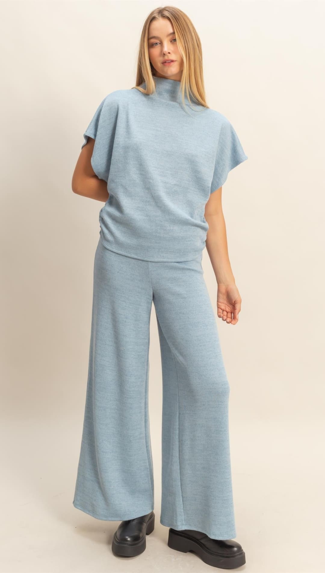 A light blue short-sleeved mock neck top and matching wide-leg pants.