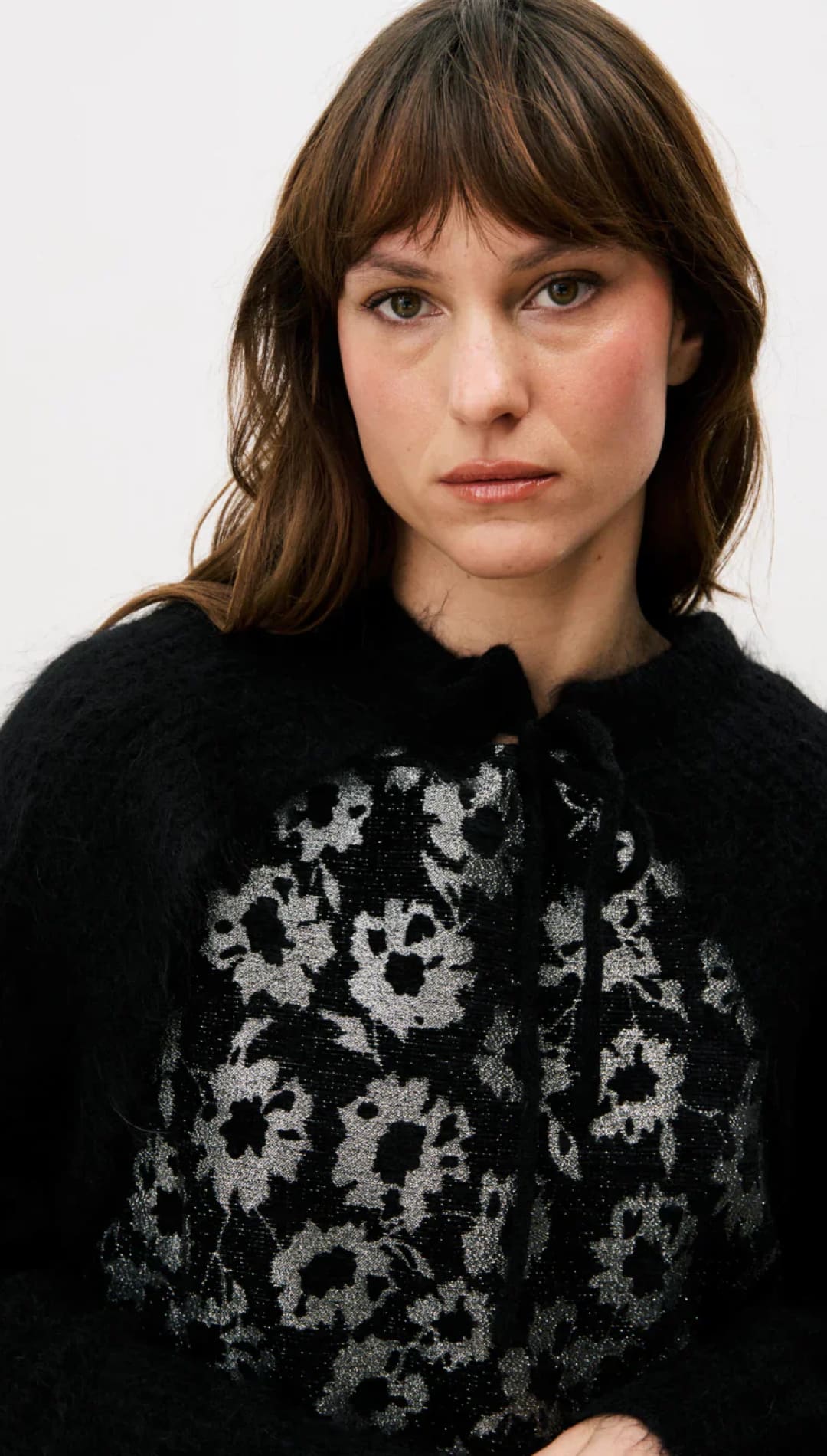 Black floral embroidered sweater with lace details.