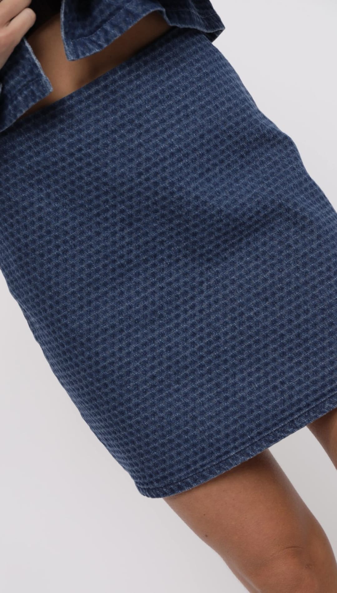Blue waffle-textured denim skirt.