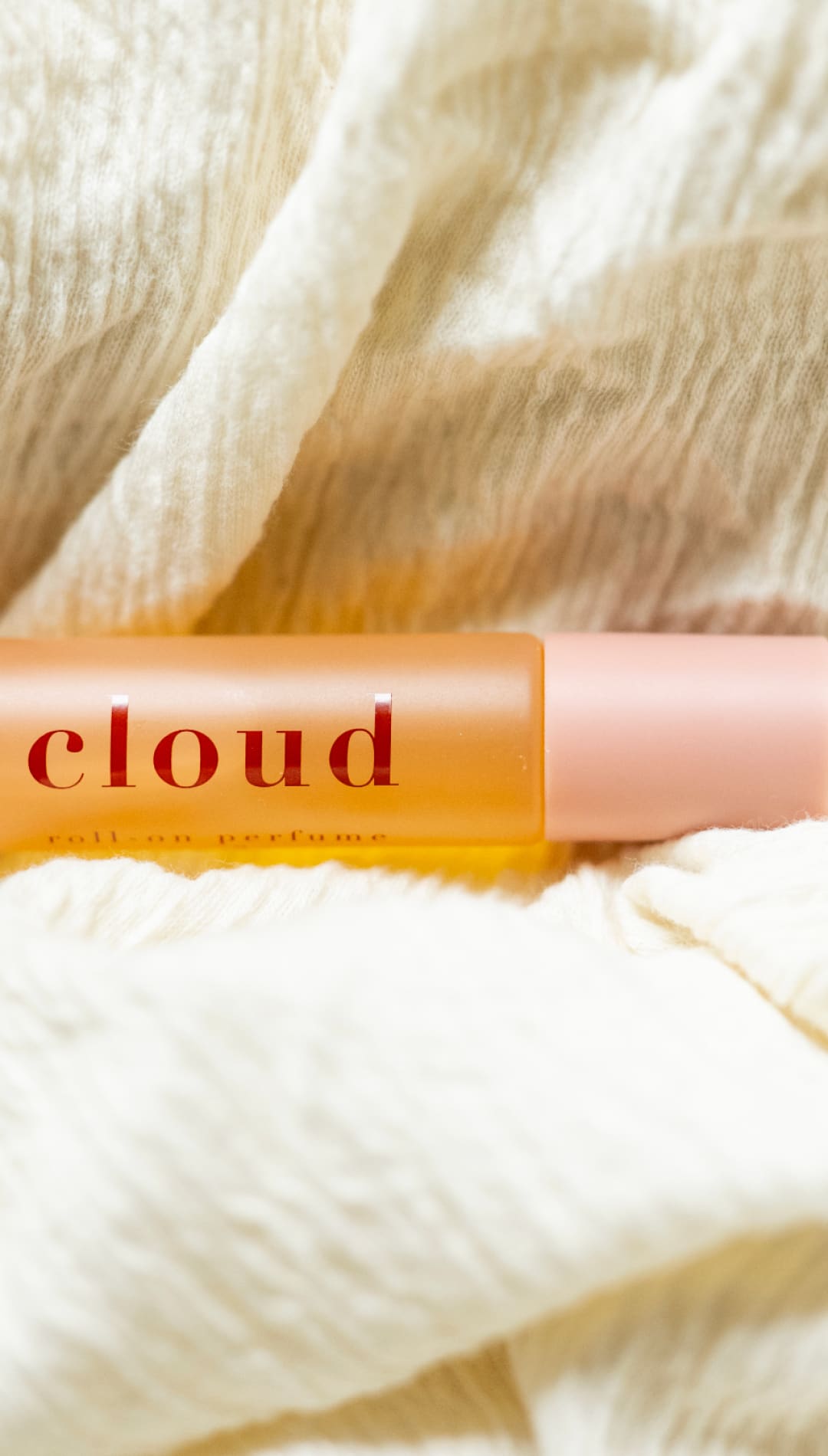 Cloud orange and pink glass bottle with white label.