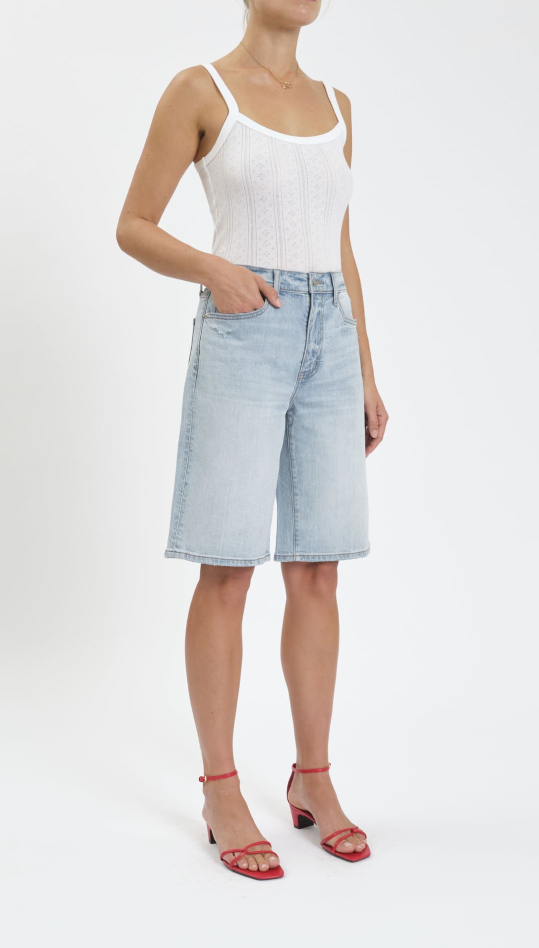 Woman’s white tank top and denim shorts.
