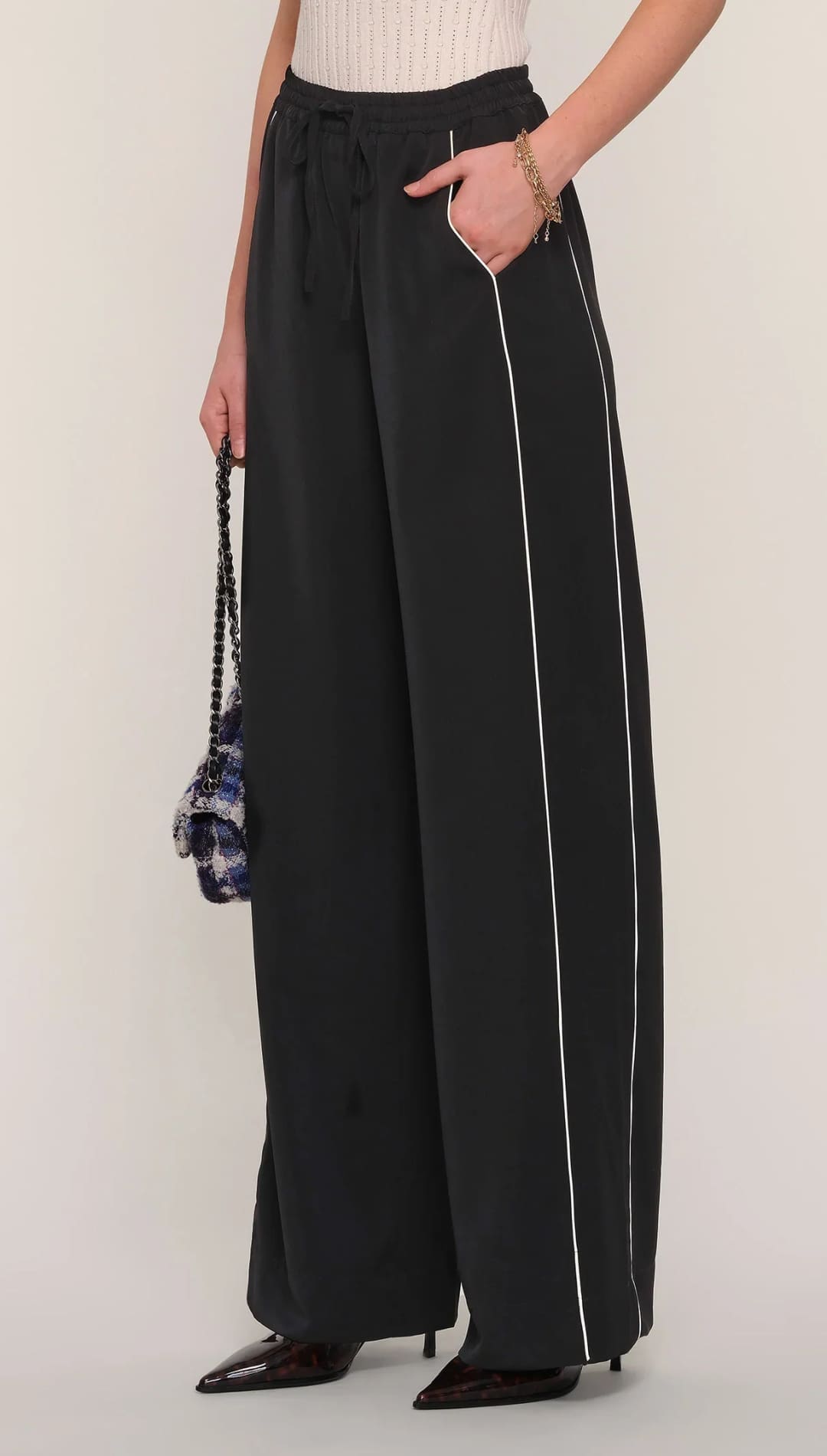 Black wide-leg track pants with white side stripes and a drawstring waist.