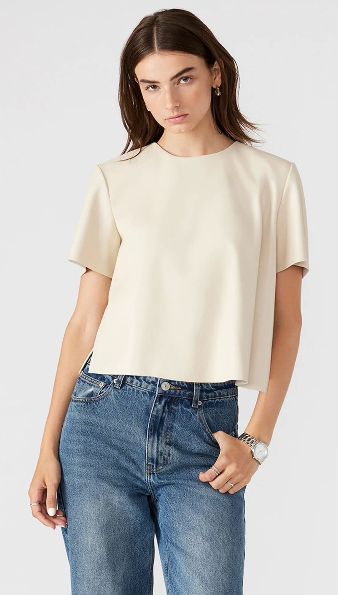 An off-white short-sleeved top made of a smooth fabric.