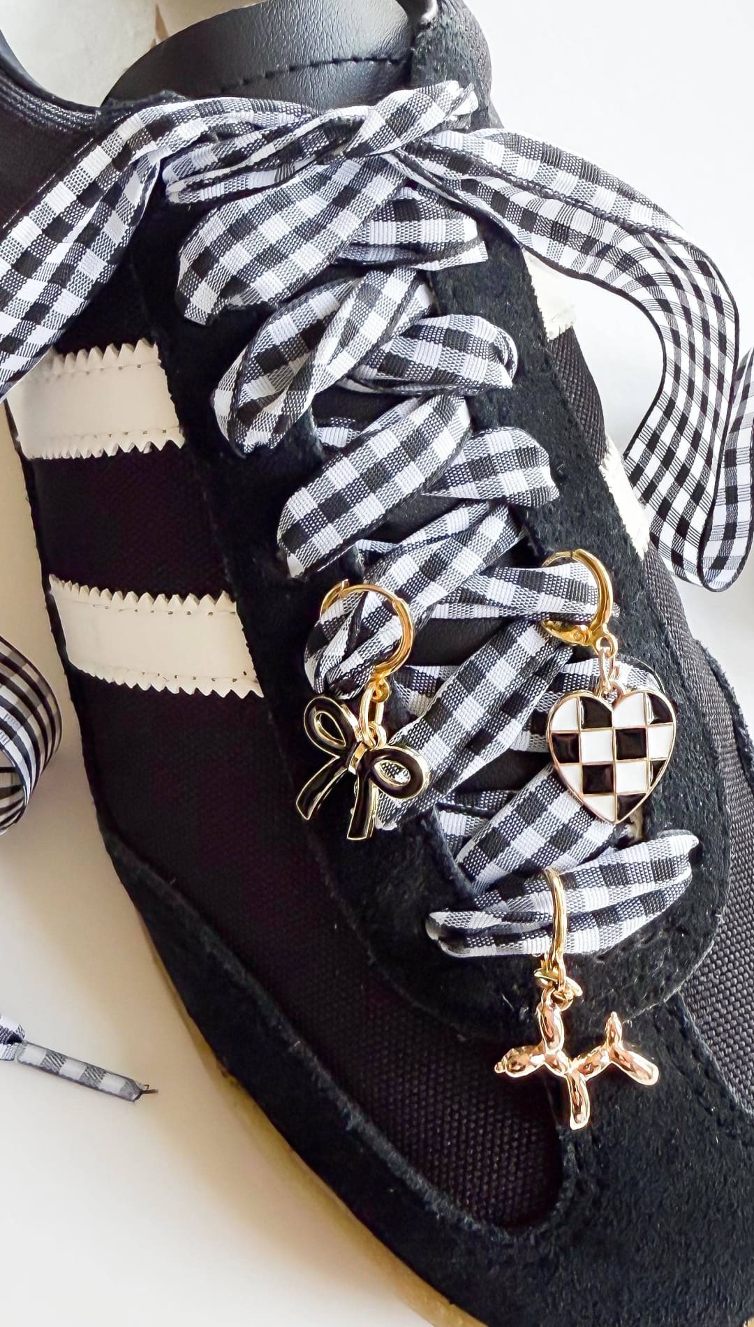 Black sneaker with gingham ribbon laces.