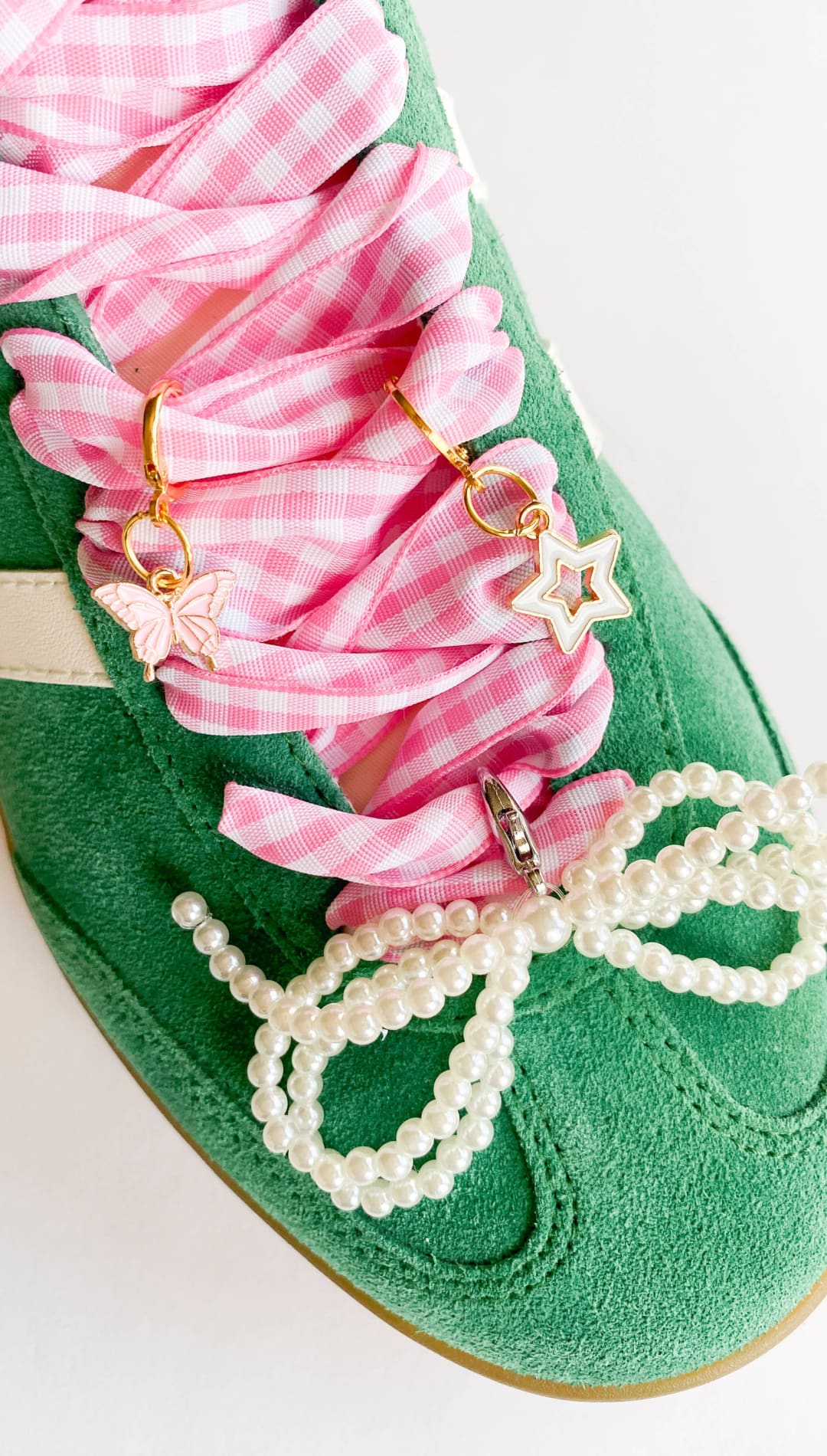 Green sneaker with pink gingham laces and pearl embellishments.