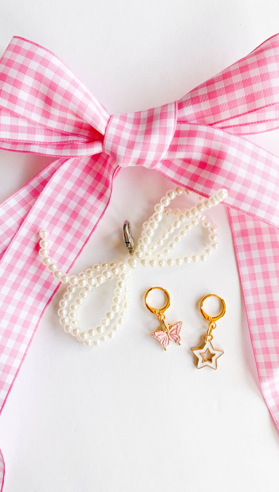 Pink gingham bow with jewelry.