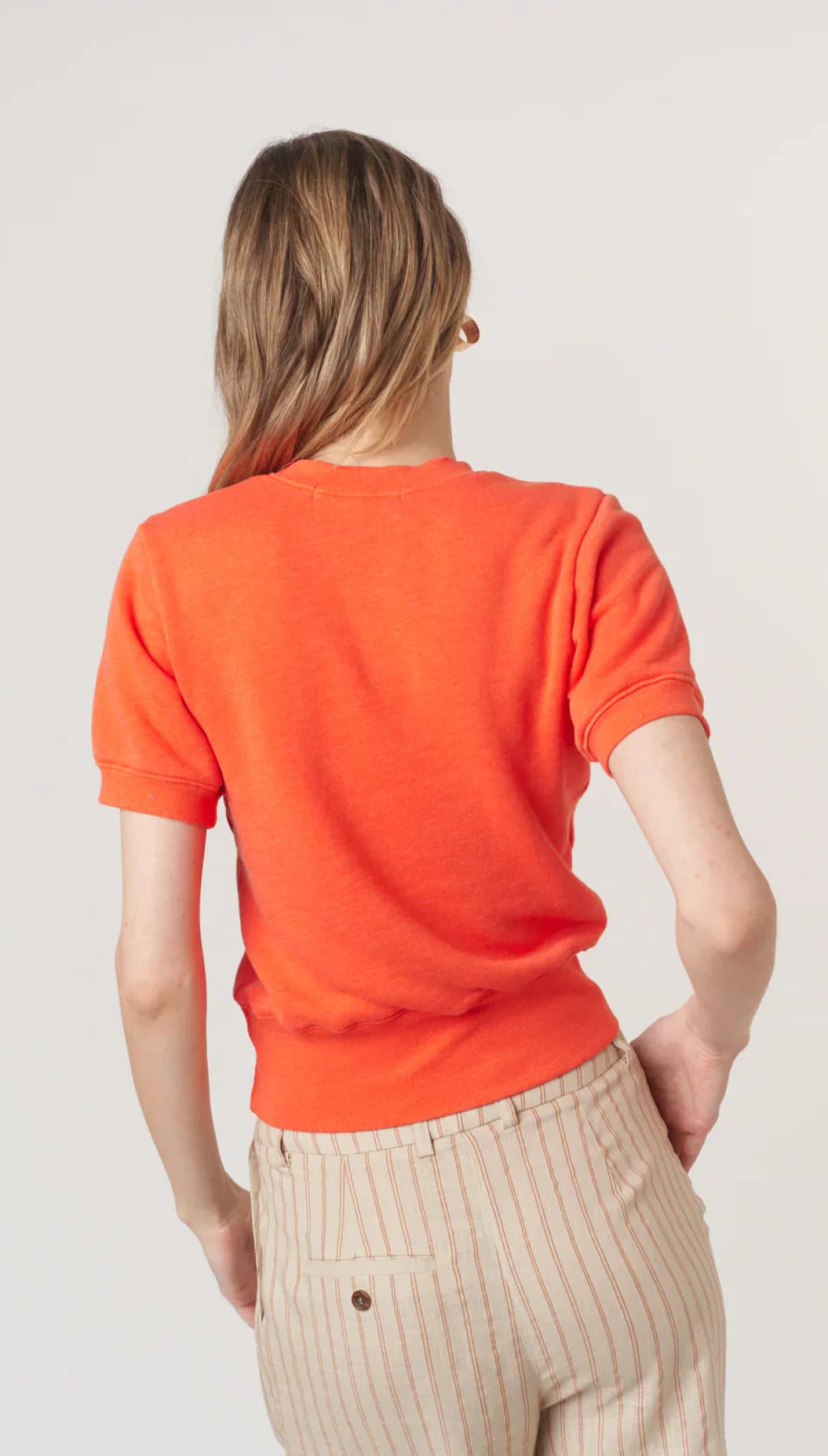 Woman’s orange short-sleeved shirt.