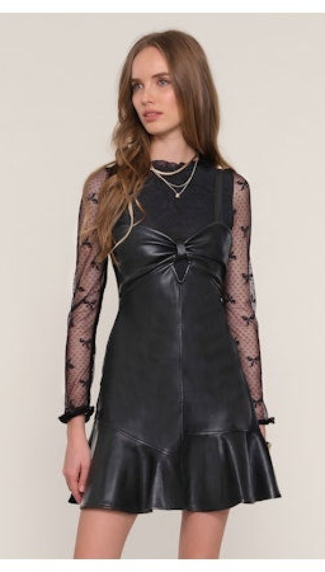 Black faux leather mini dress with a sheer long-sleeved top.
