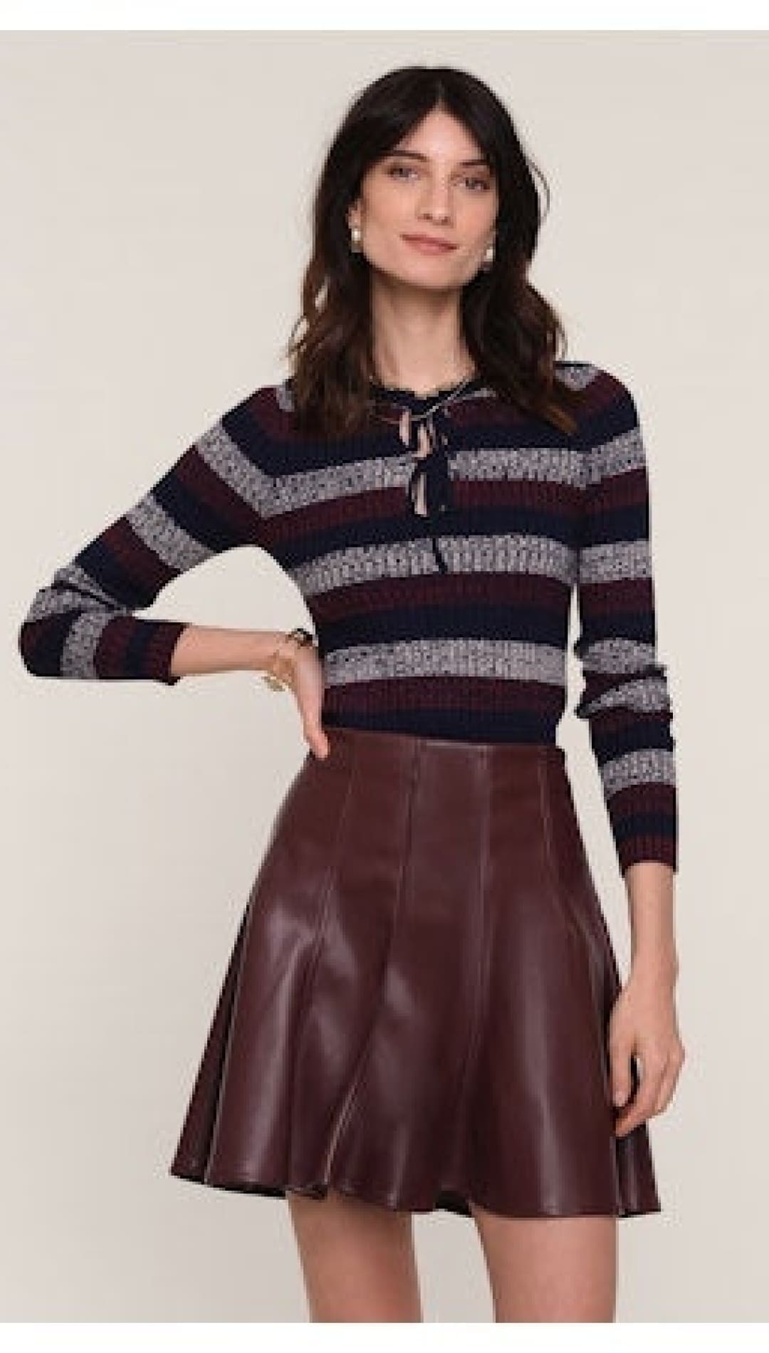 A long-sleeved, striped knit top with a tie-neck detail.