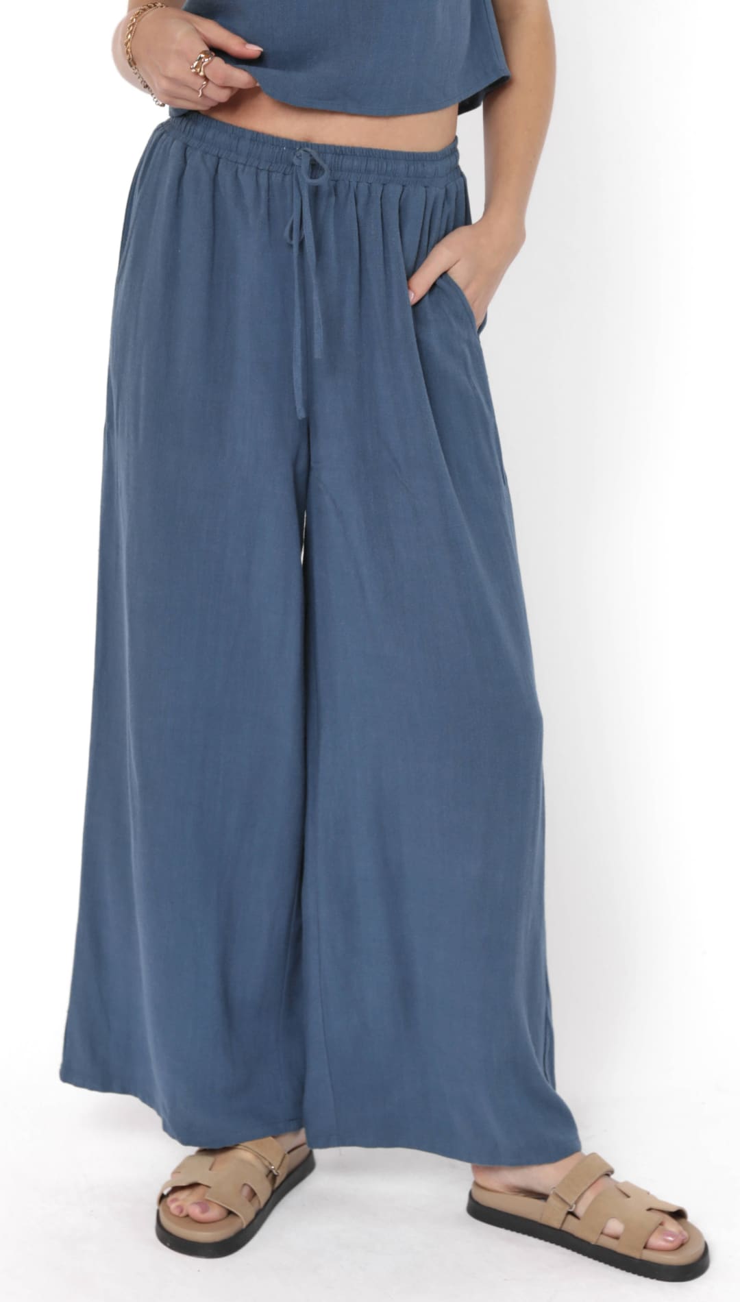 Women’s loose-fitting blue wide-leg pants with a drawstring waist and side pockets.