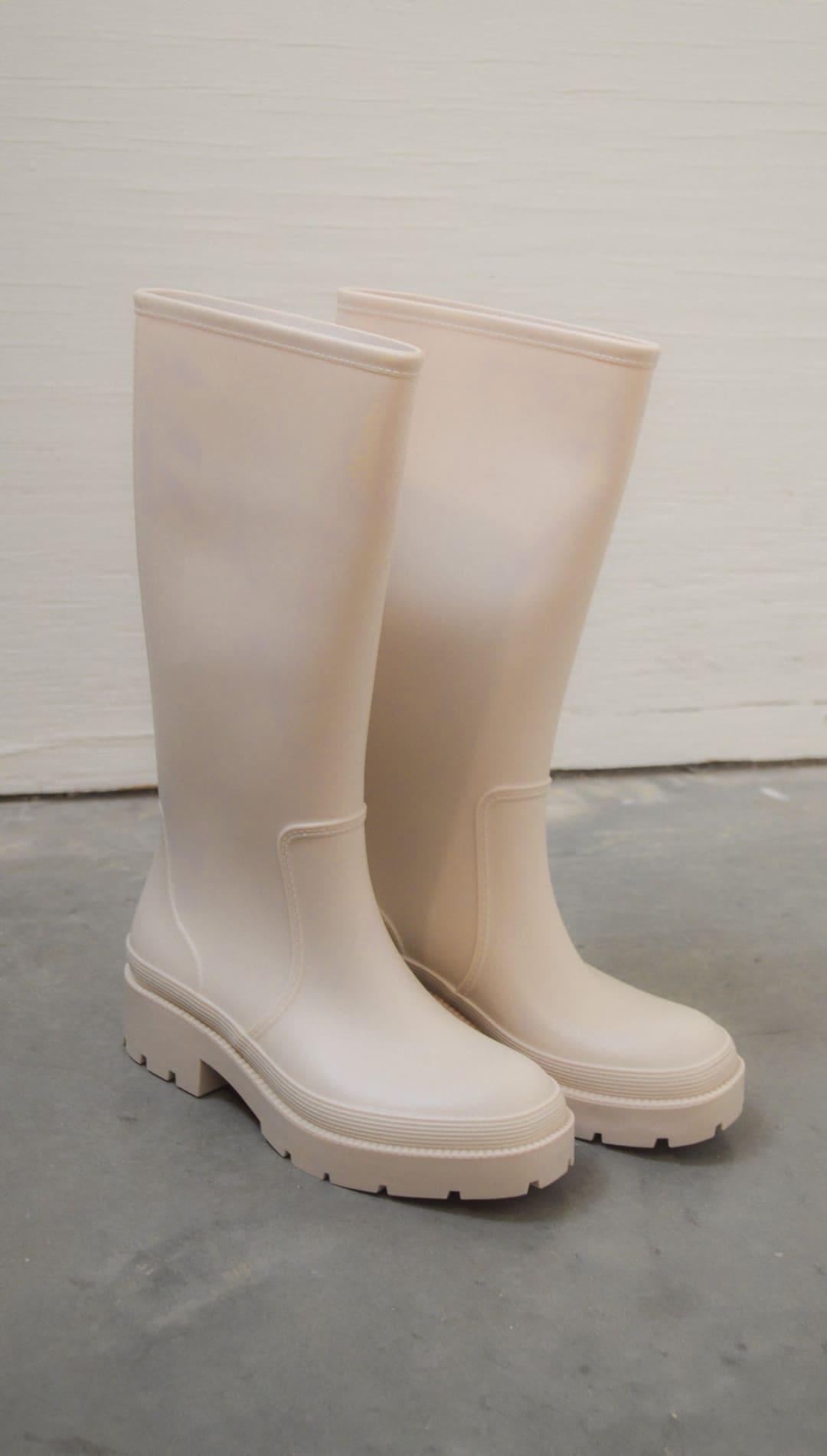 Beige rubber rain boots.
