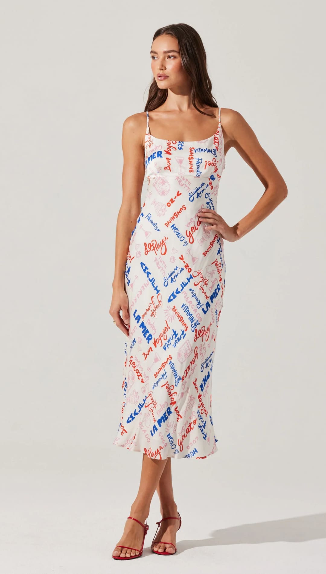 White midi slip dress with red and blue lettering.