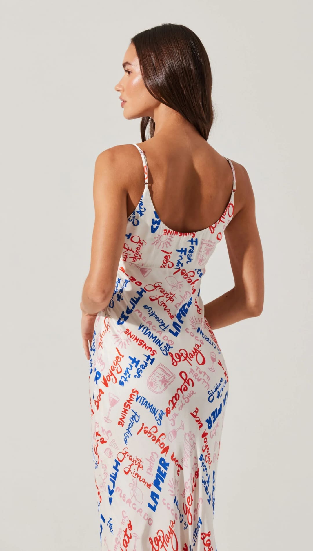White slip dress with colorful text print.