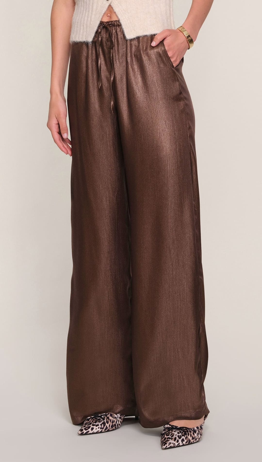 Brown satin wide-leg pants with pockets and a high waistband.