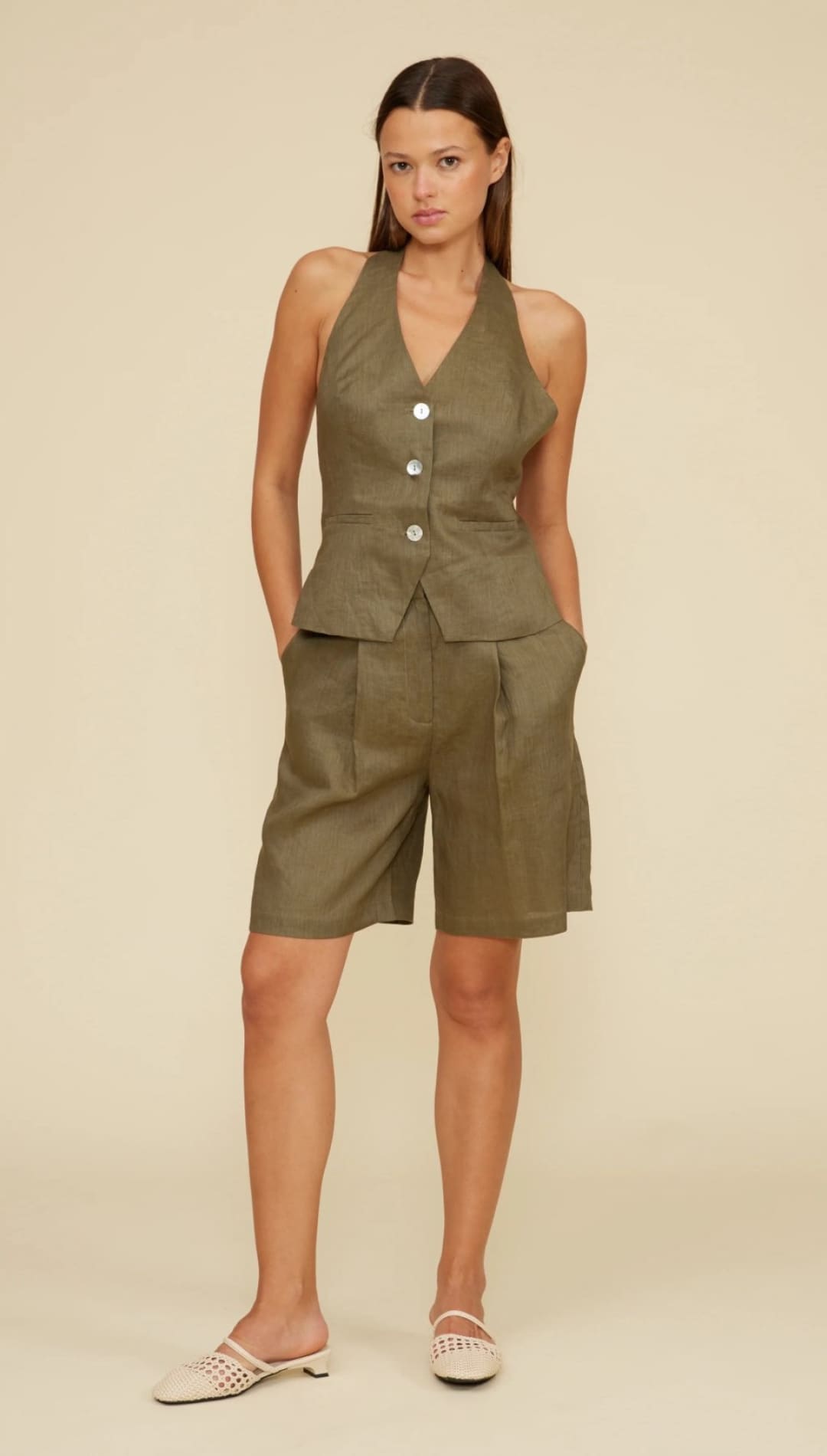 Woman in olive green halter top and shorts.