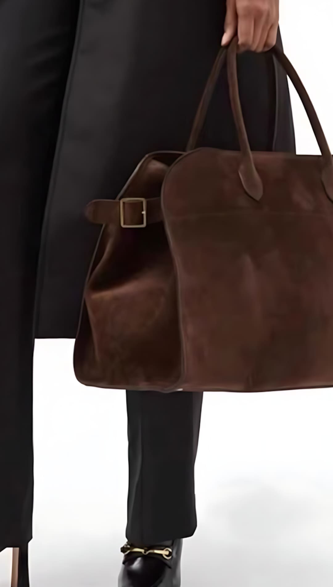 Brown leather tote bag with buckle detail and long handles.