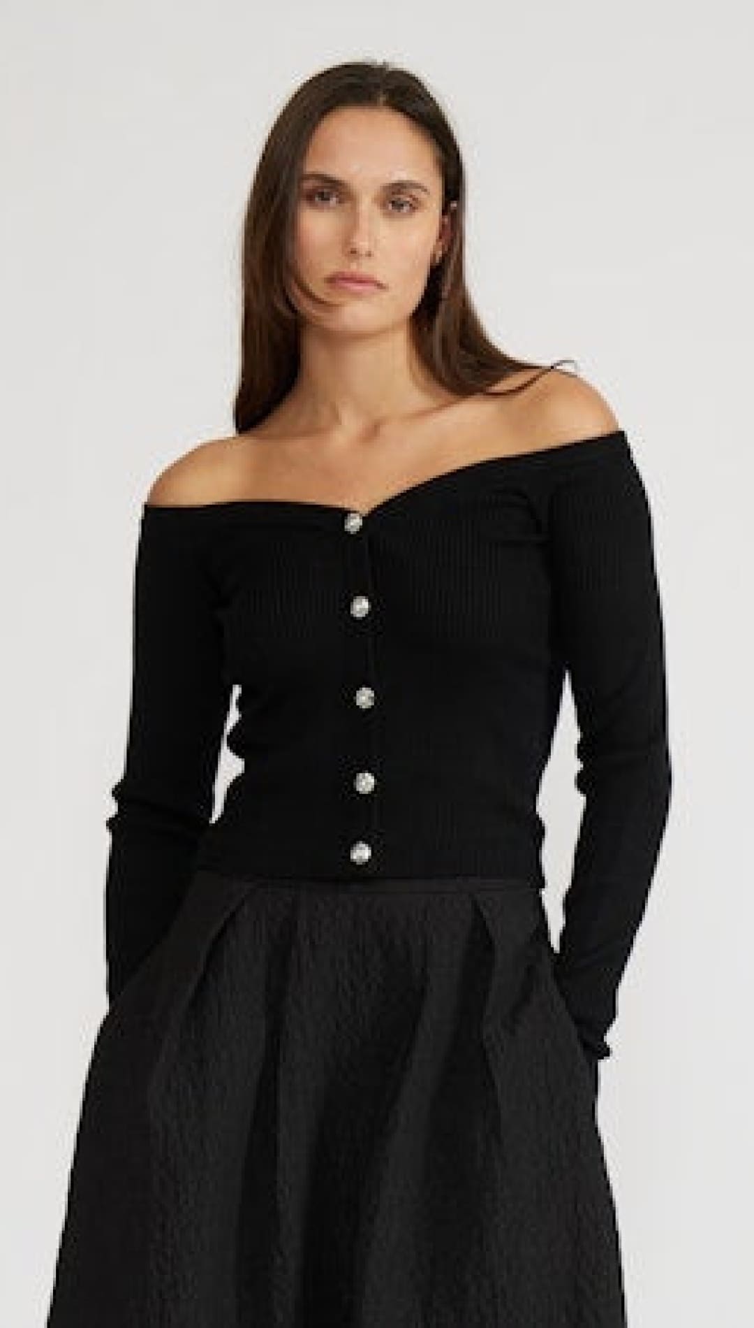 Black off-the-shoulder sweater with buttons down the front.