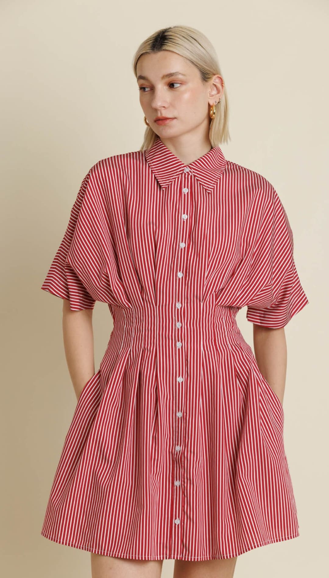 A red and white striped shirtdress with short, voluminous sleeves, a cinched waist, and a flared skirt with pockets.