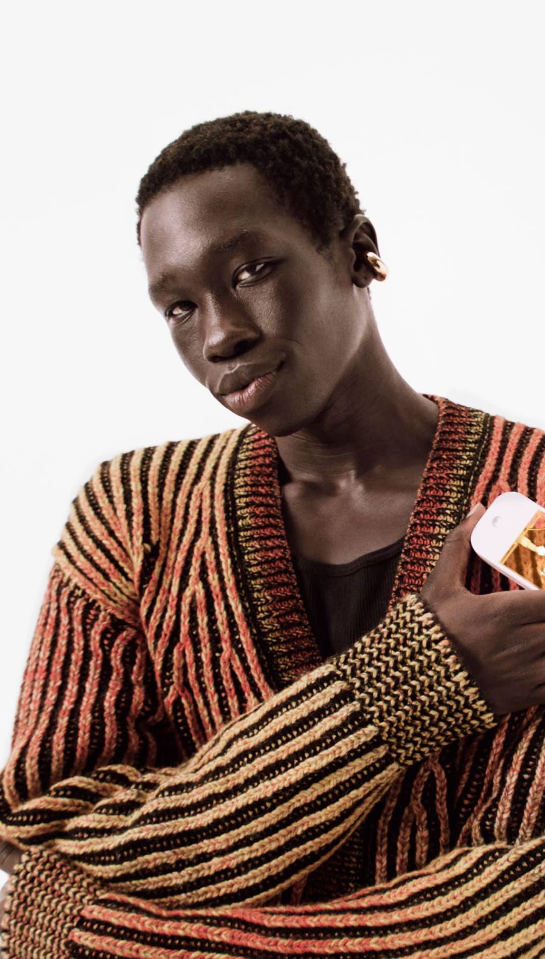 Striped sweater with orange and brown hues, textured knit design.