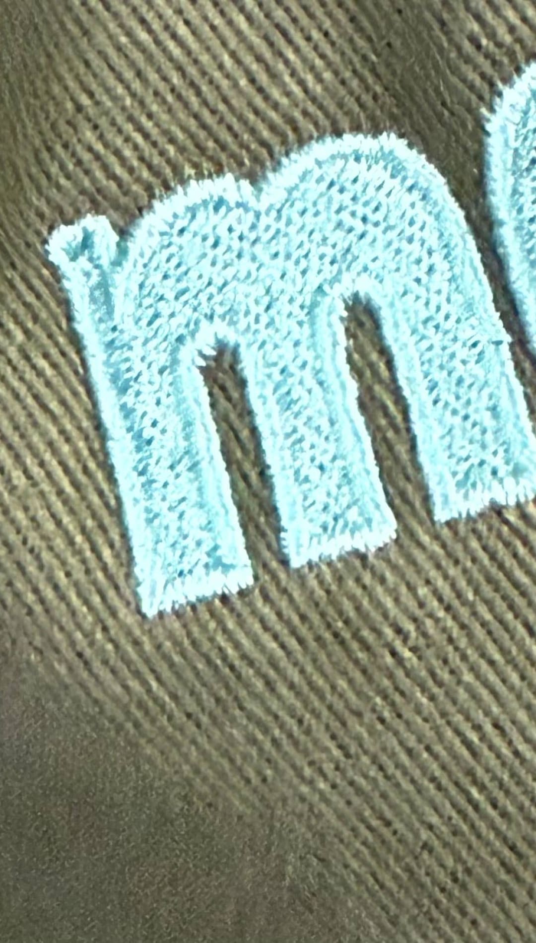Embroidered light blue letters.