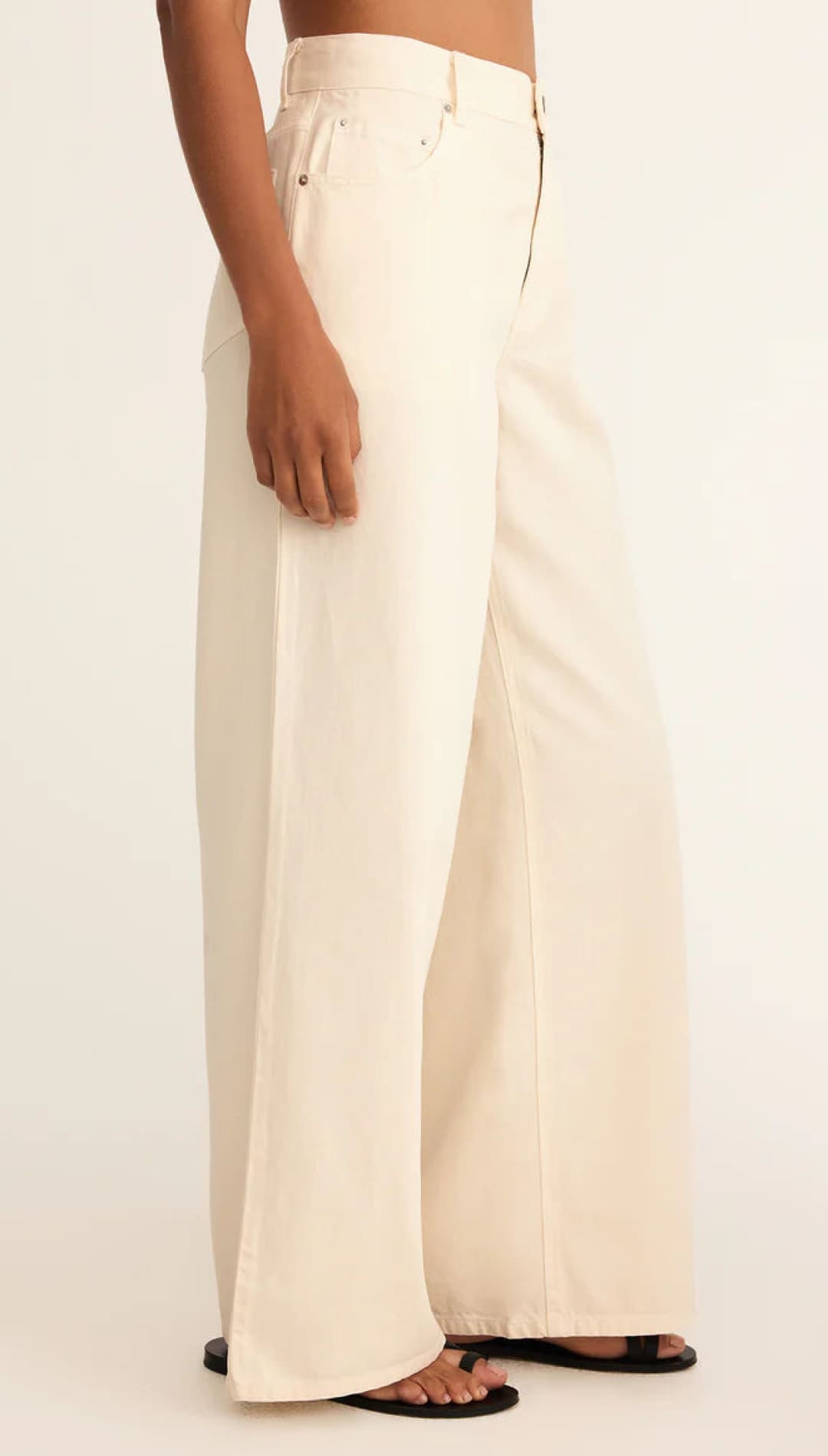 Cream-colored wide-leg pants with a high waist and button fly, likely made of cotton or linen.