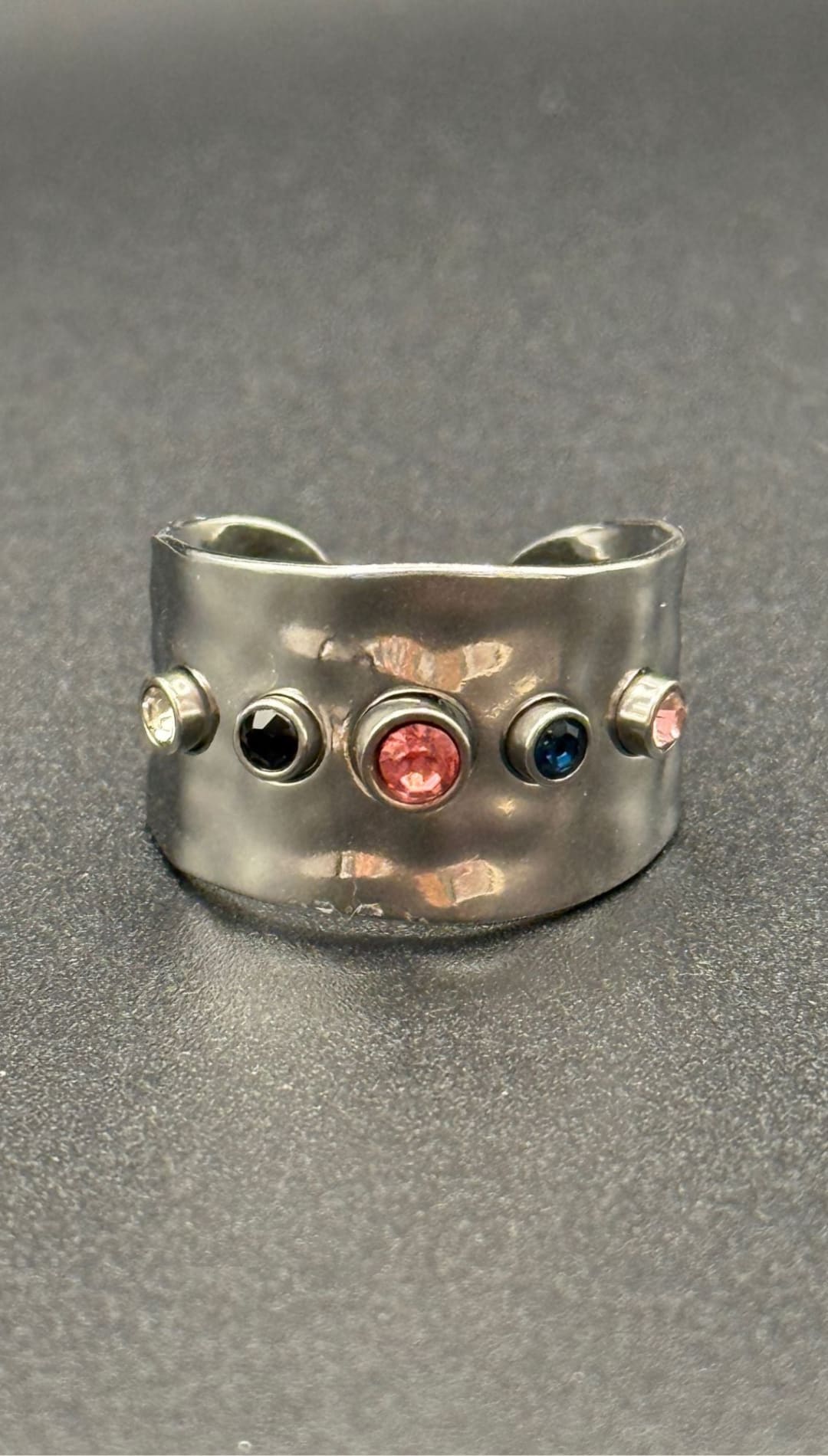 Silver ring with colorful gemstones.