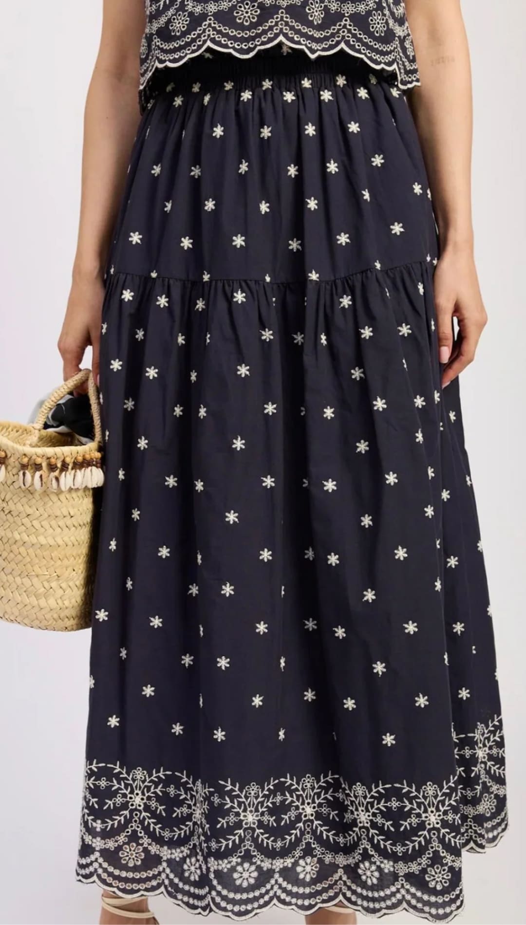 Navy blue tiered maxi skirt with white floral embroidery.