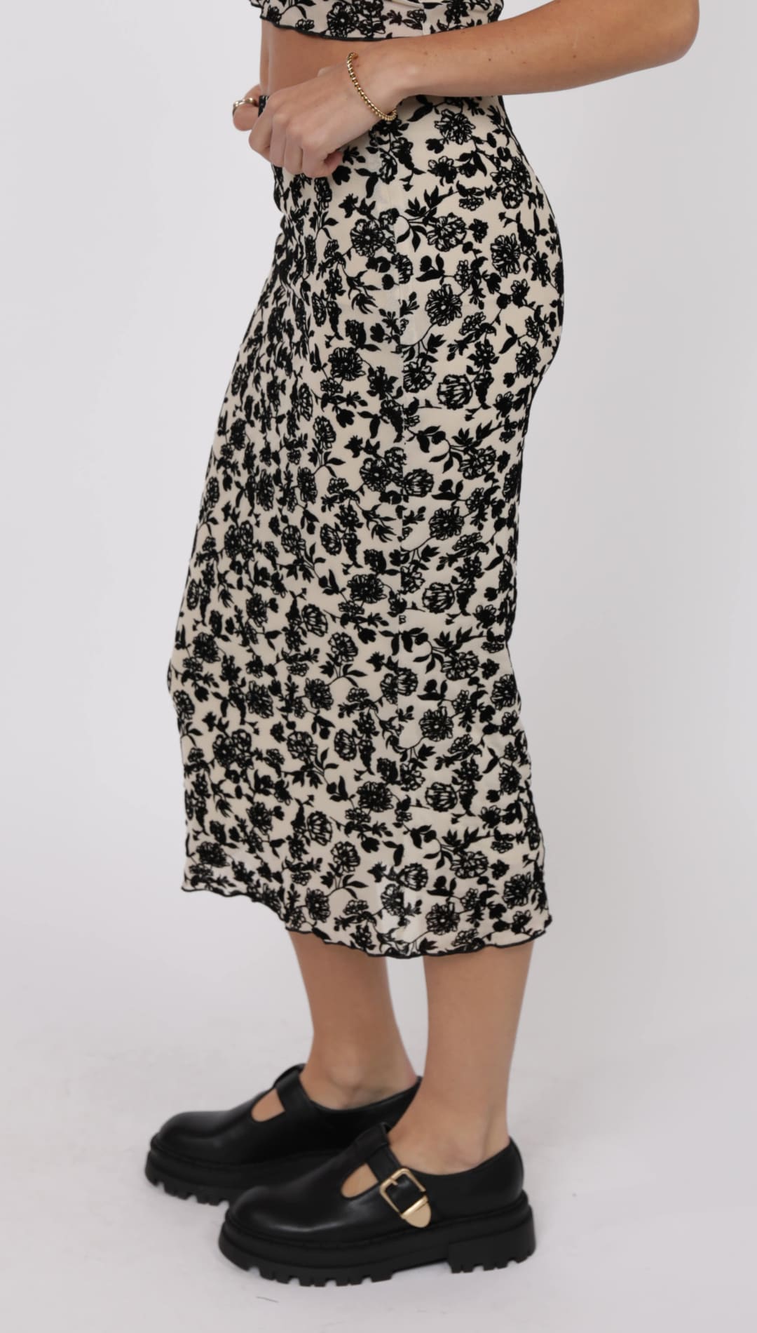 A midi-length black and white floral skirt with a ruffled hem.
