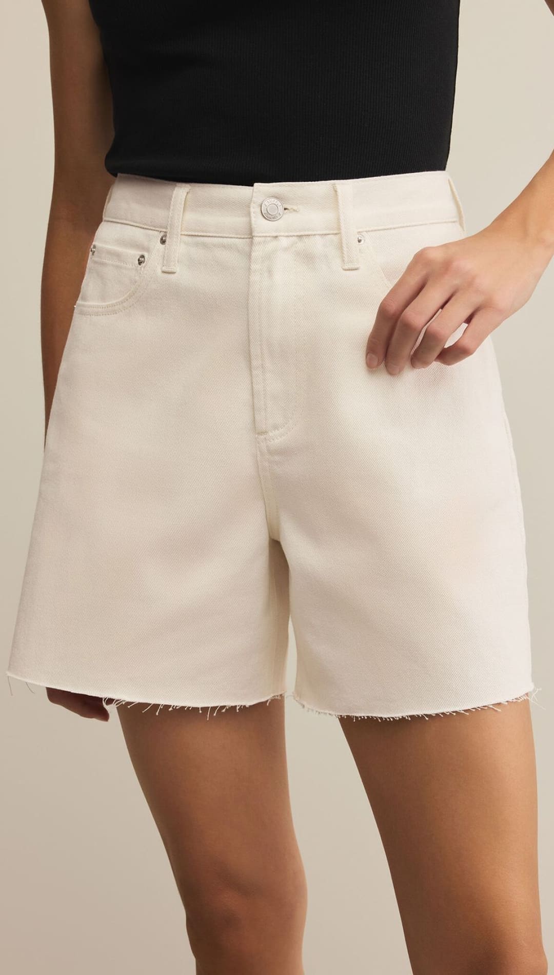 White high-waisted denim shorts with a raw hem.