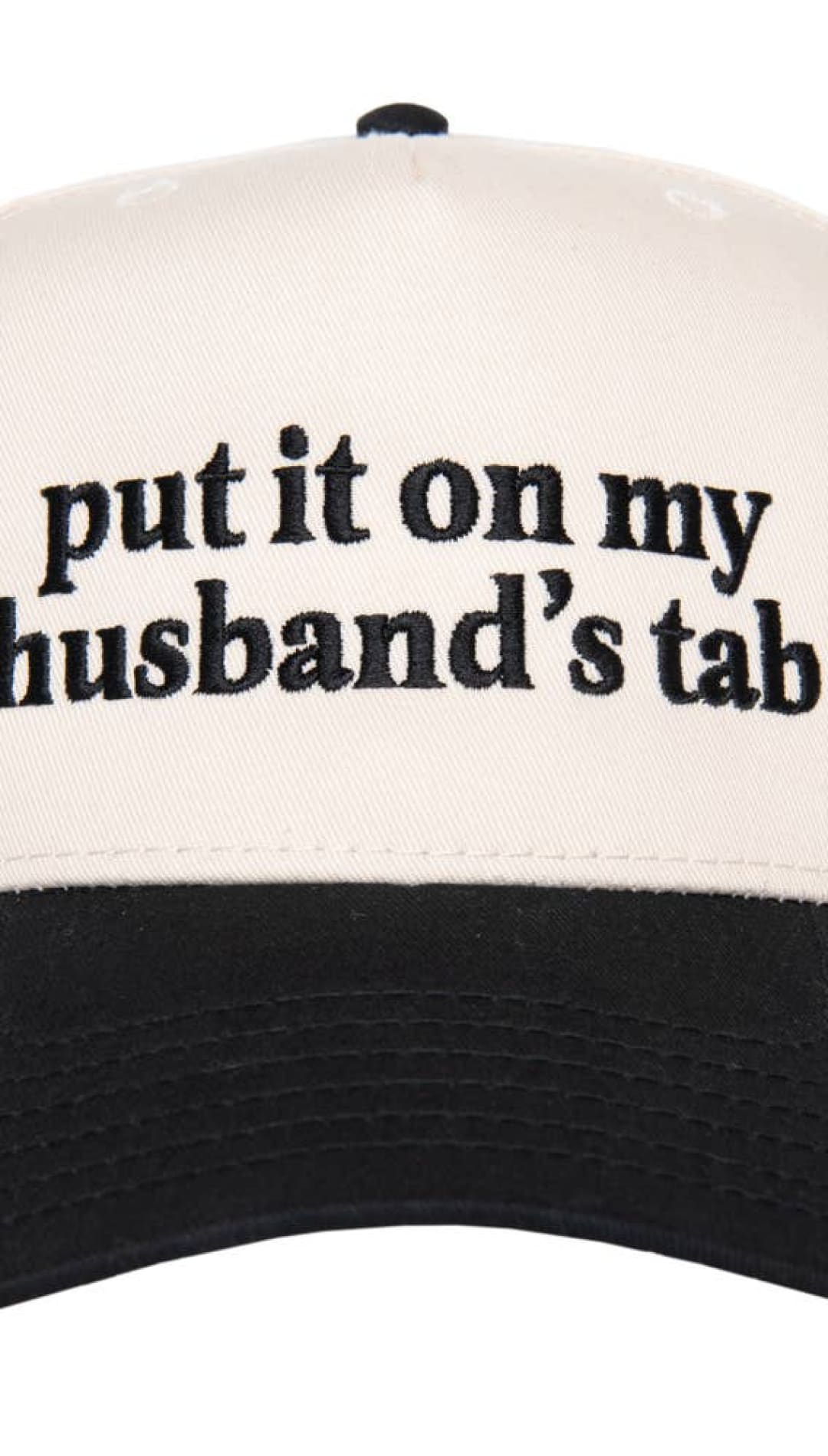 Cream and black trucker hat with ’put it on my husband’s tab’ text.