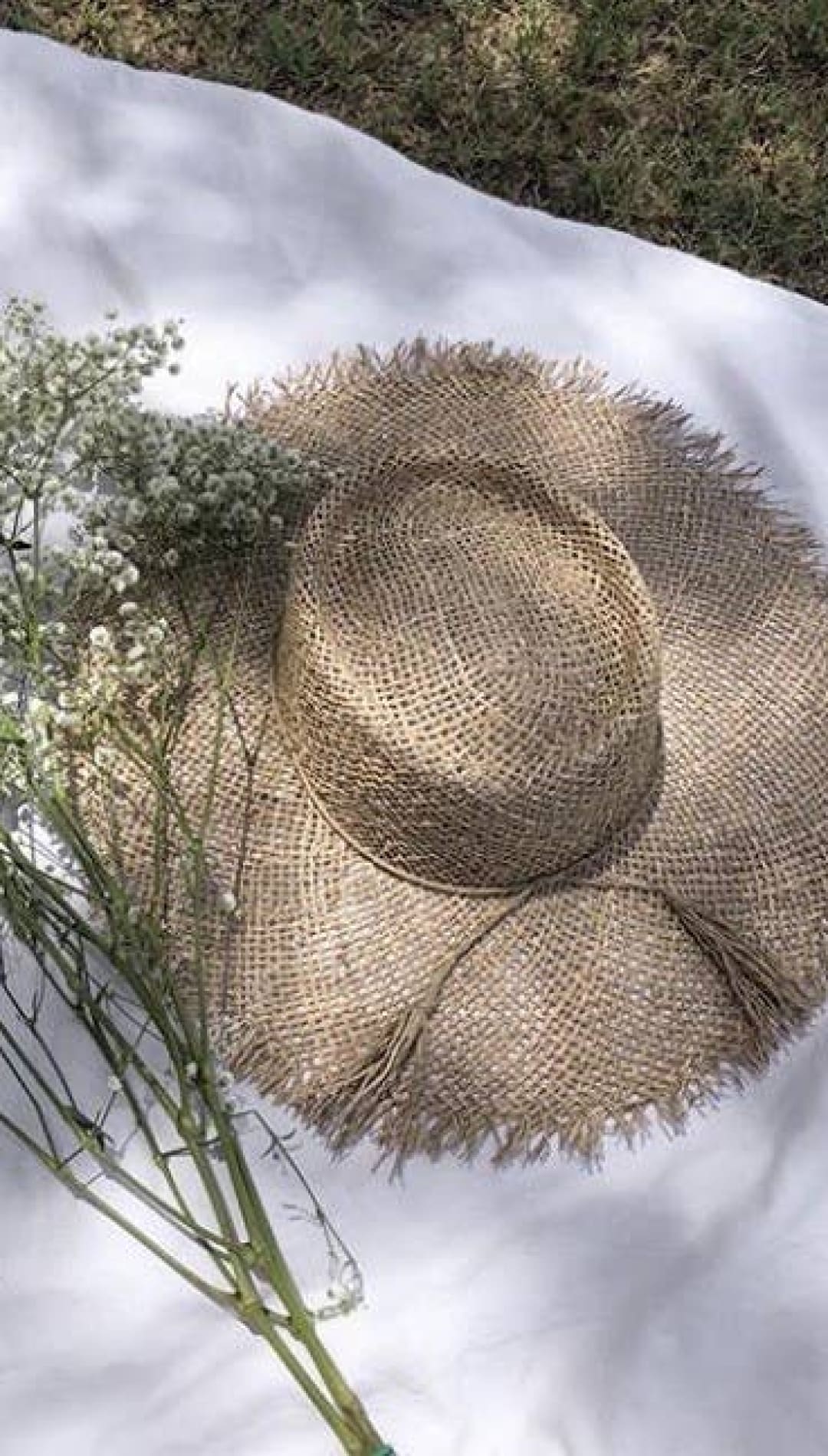 Woven straw sunhat with frayed brim.