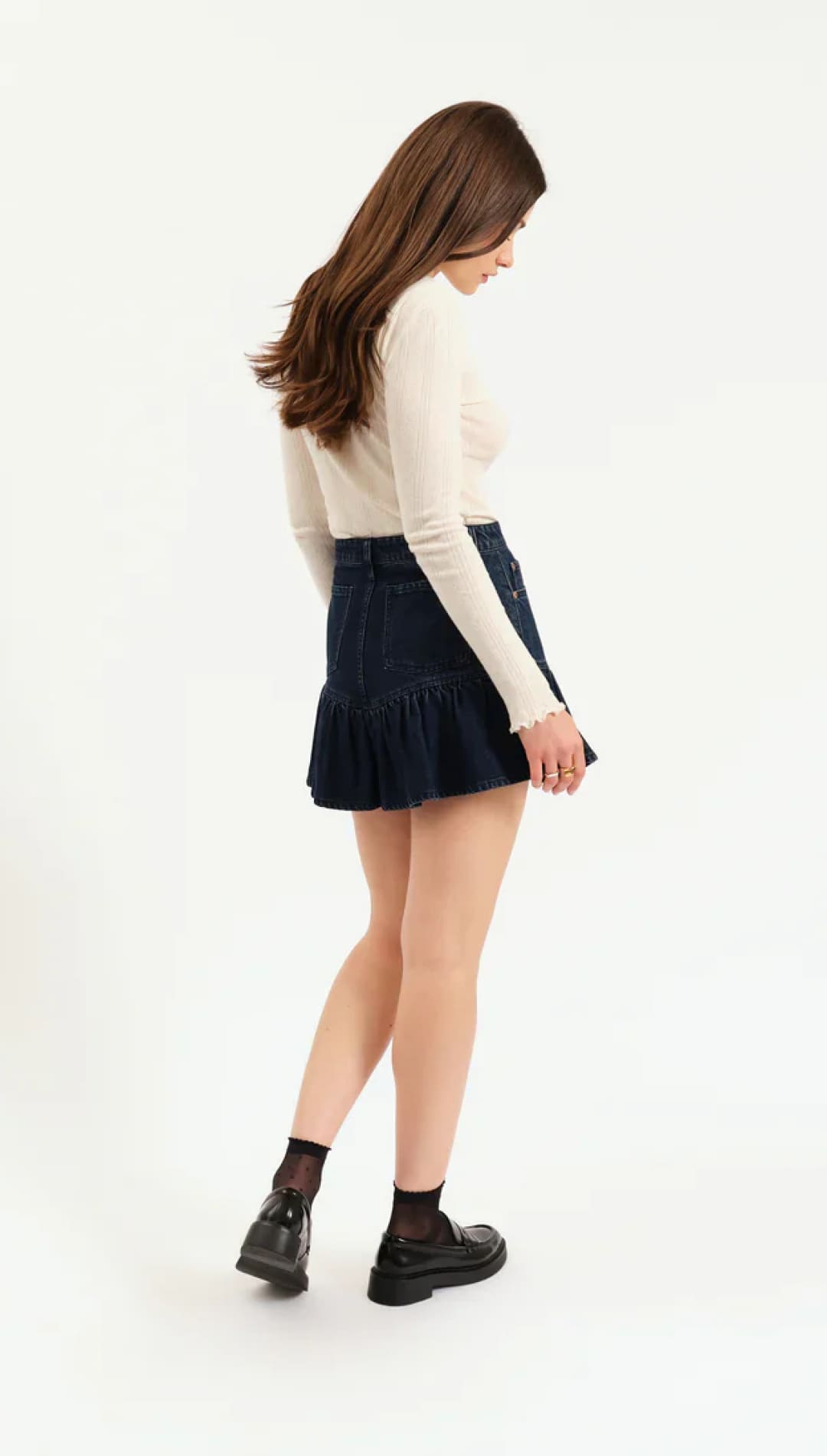 Denim skirt with ruffled hem and black lace-up boots.