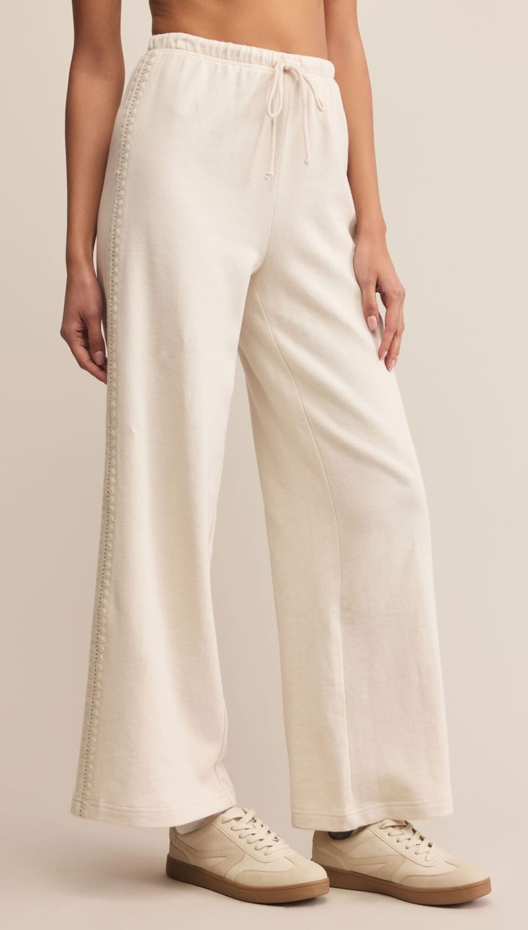 Cream-colored wide-leg pants with drawstring waist and side pockets, likely made of linen or cotton blend.