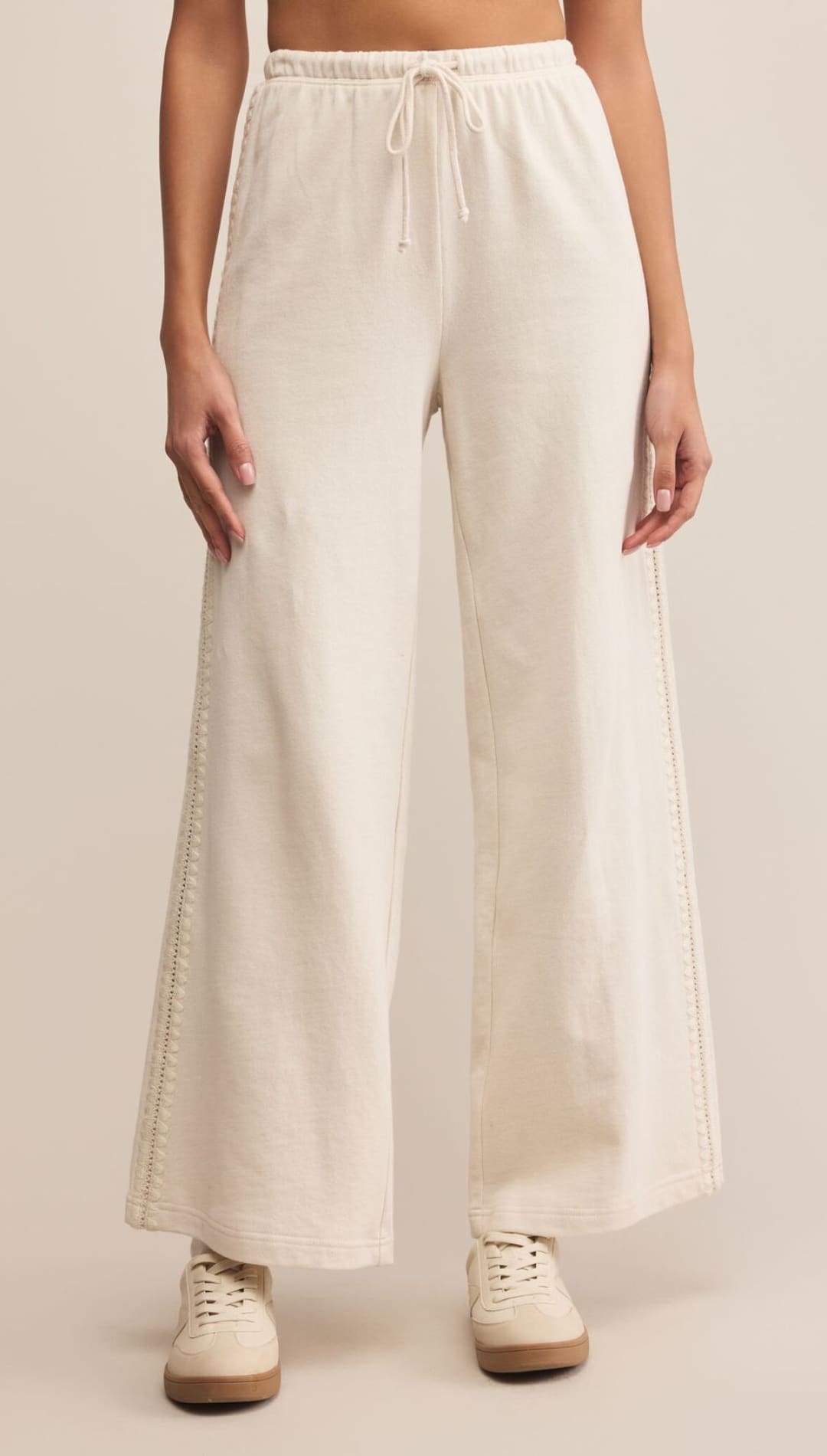 White linen wide-leg pants with drawstring waist and side slits.