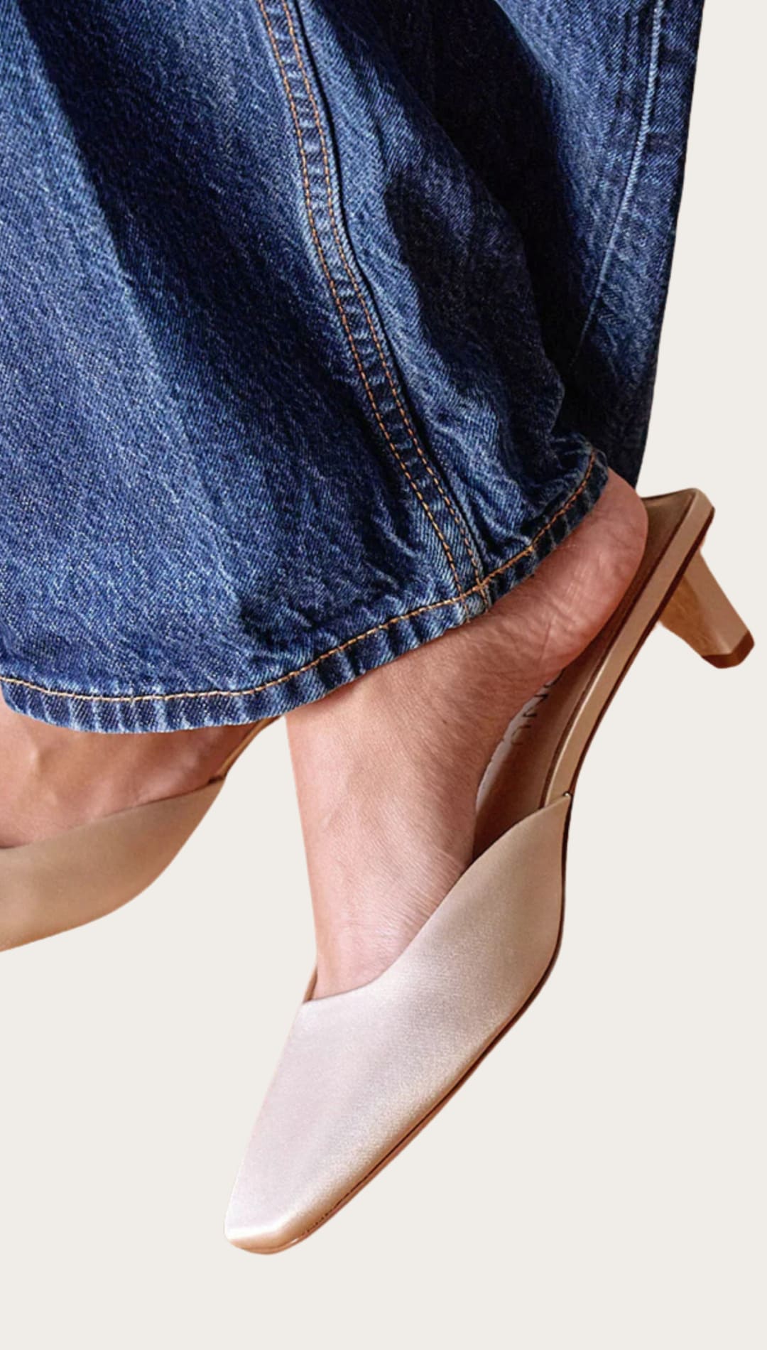 Beige pointed-toe heeled mules.