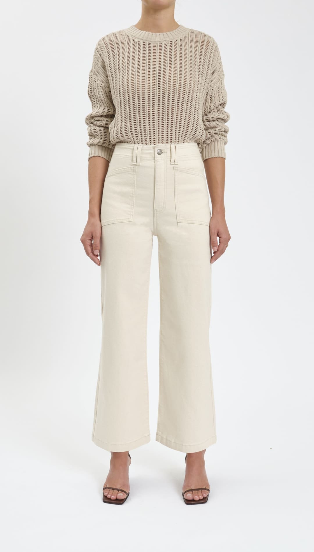 Woman’s beige knit sweater and wide-leg pants outfit.