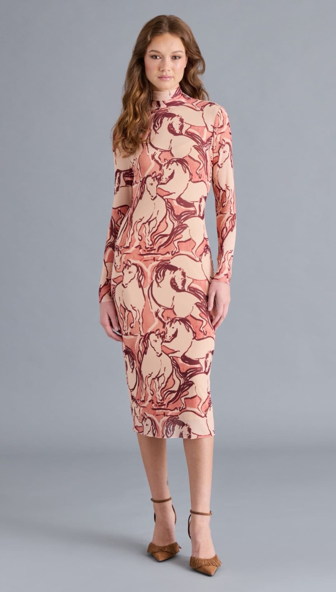 A long-sleeved, high-neck midi dress in a pink and brown horse print.