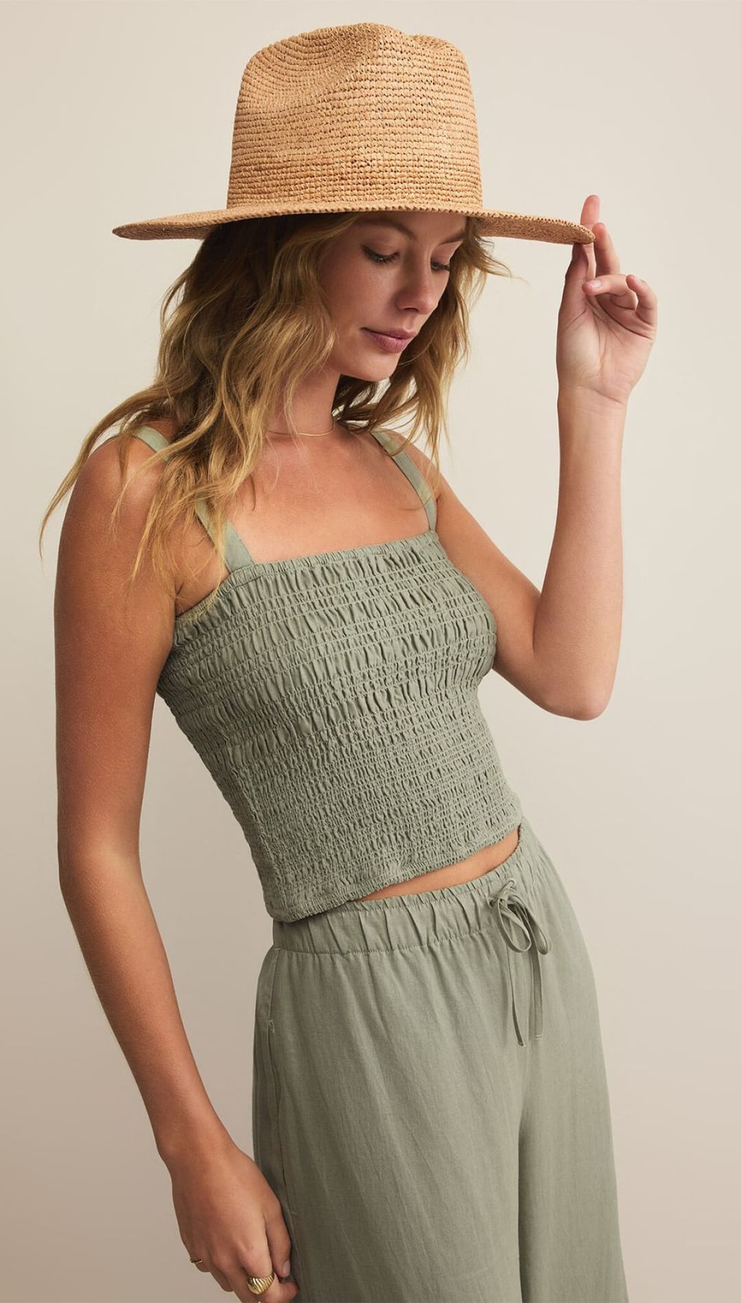 Woman in green smocked top and straw hat.