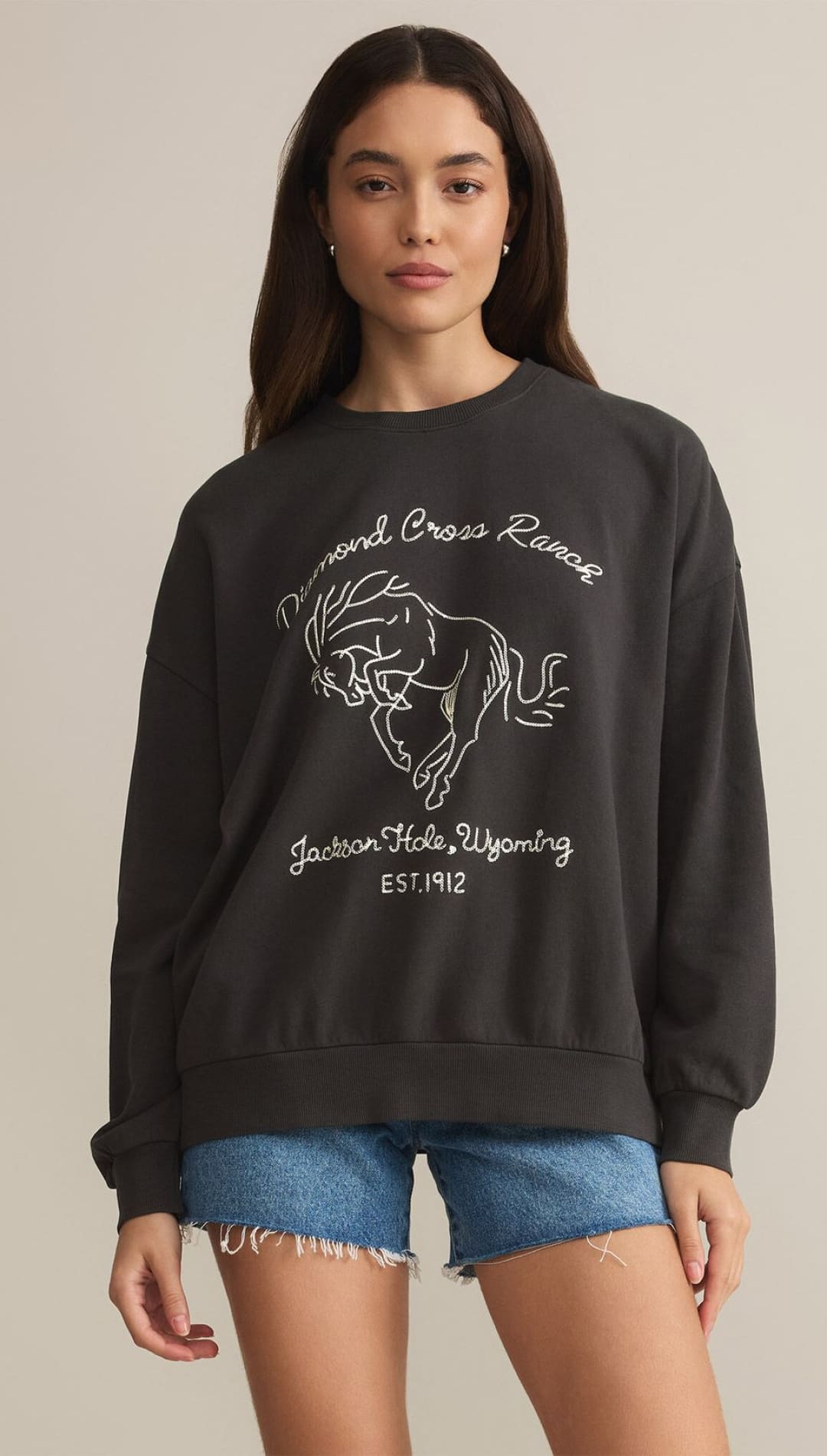 A long-sleeved dark gray sweatshirt with a white outline graphic of a bucking horse and text.